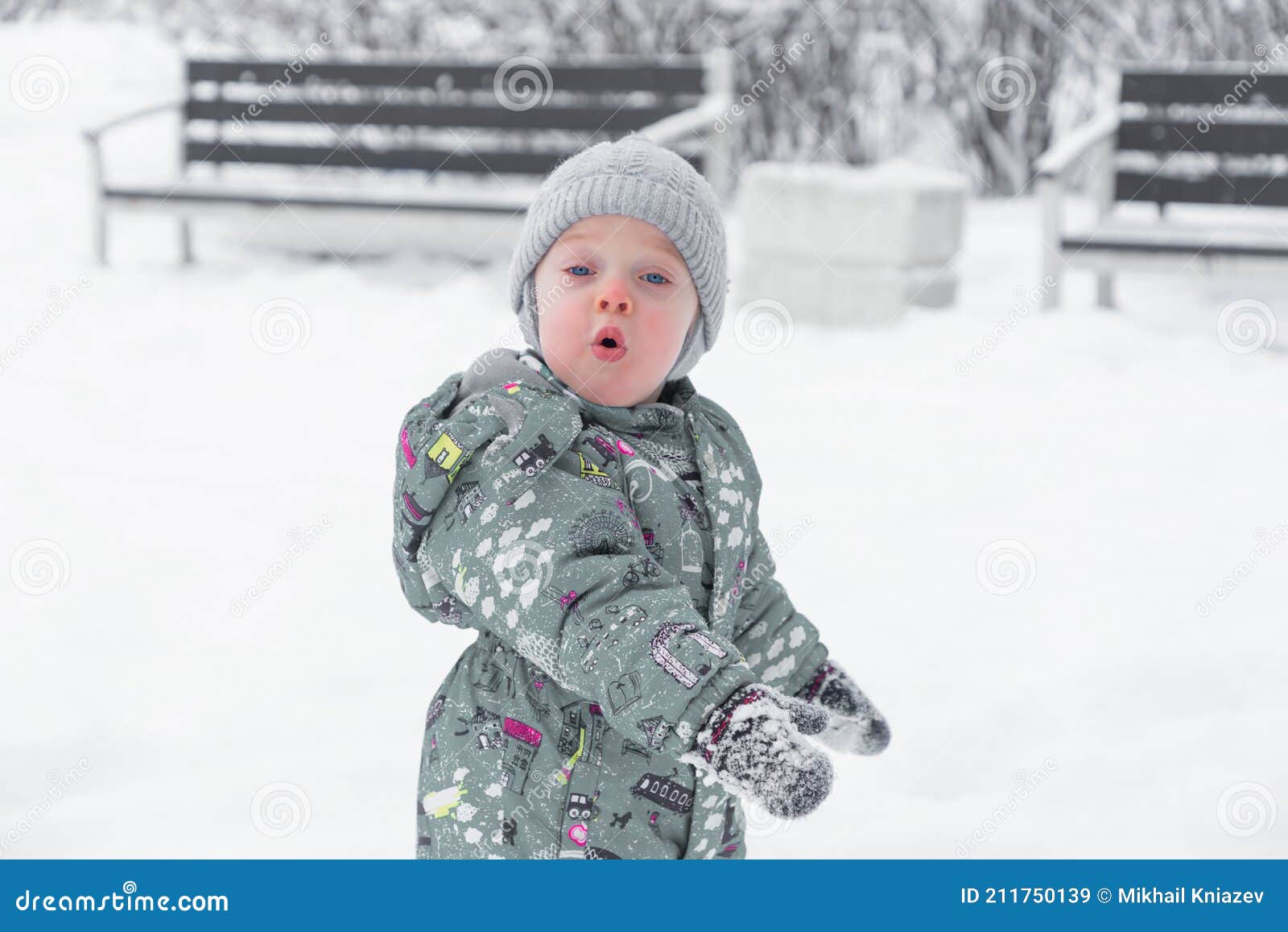 Un Bebé En Un Mono Cálido Se Para En Una Deriva De Nieve Durante Una Nevada  En El Parque. Imagen de archivo - Imagen de bebé, muchacho: 211750139