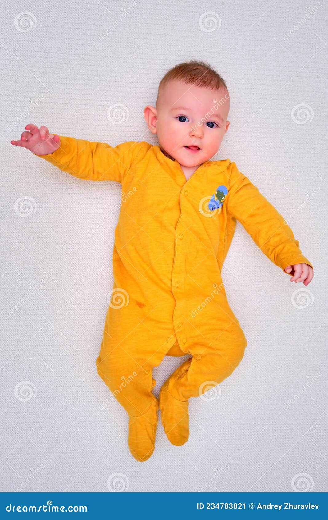 Un Bebé Feliz Tendido En Una Alfombra De Juego En La Vista Superior Pijama Amarillo. Niño Sonriente De Larga Duración En Espac Imagen de archivo - Imagen de mirada, longitud: 234783821