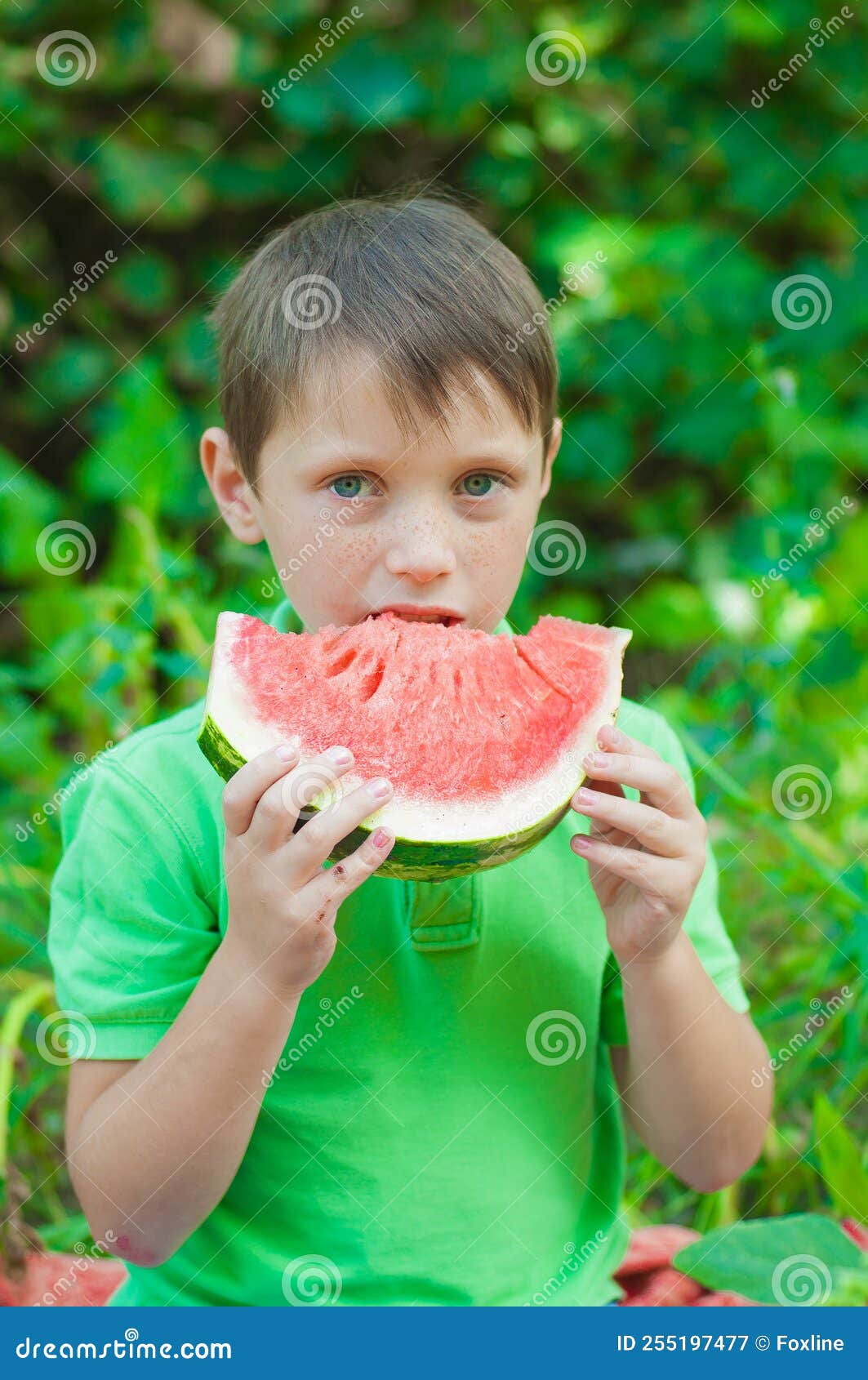 Niño feliz con camiseta roja en el jardín