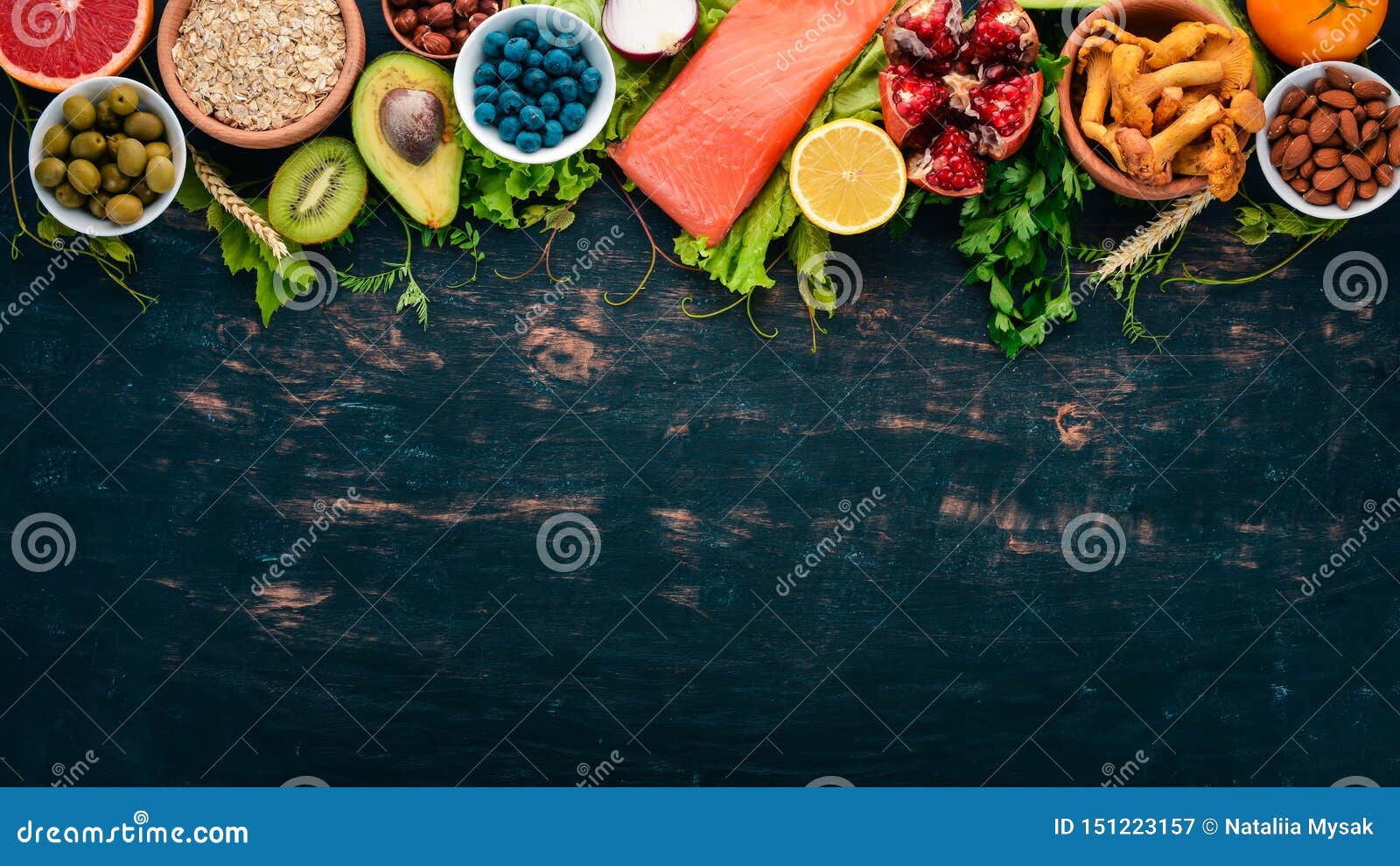 Un conjunto de alimentos sanos Pescado, nueces, proteínas, bayas, verduras y frutas Sobre un fondo de madera negra Vista superior Espacio libre para texto