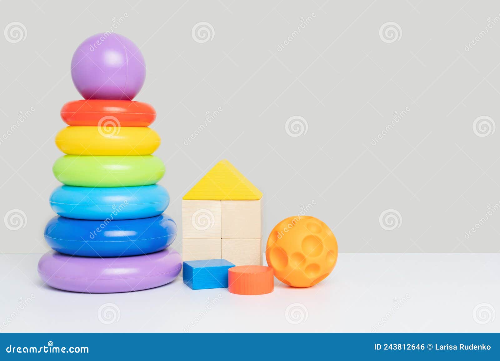 Un Conjunto De Juguetes Educativos Para Ninos En Un Fondo Gris. Una Piramide De Plastico De Color De Anillos Cubos De Madera Y Una Foto de archivo Imagen de conjunto bola