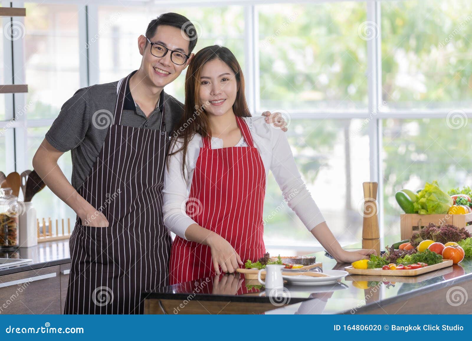 Un Couple Asiatique En Tablier Debout Dans La Cuisine Photo stock - Image  du cuisine, tablier: 164806020