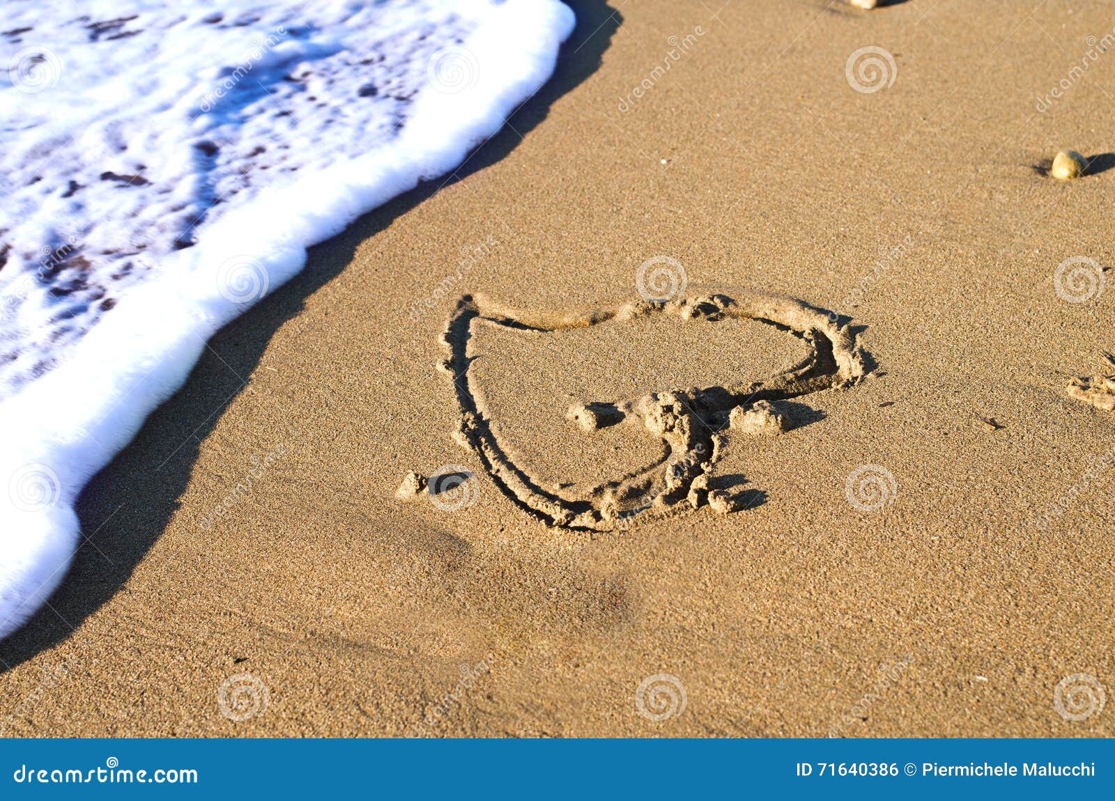 Un cuore sulla spiaggia al tramonto