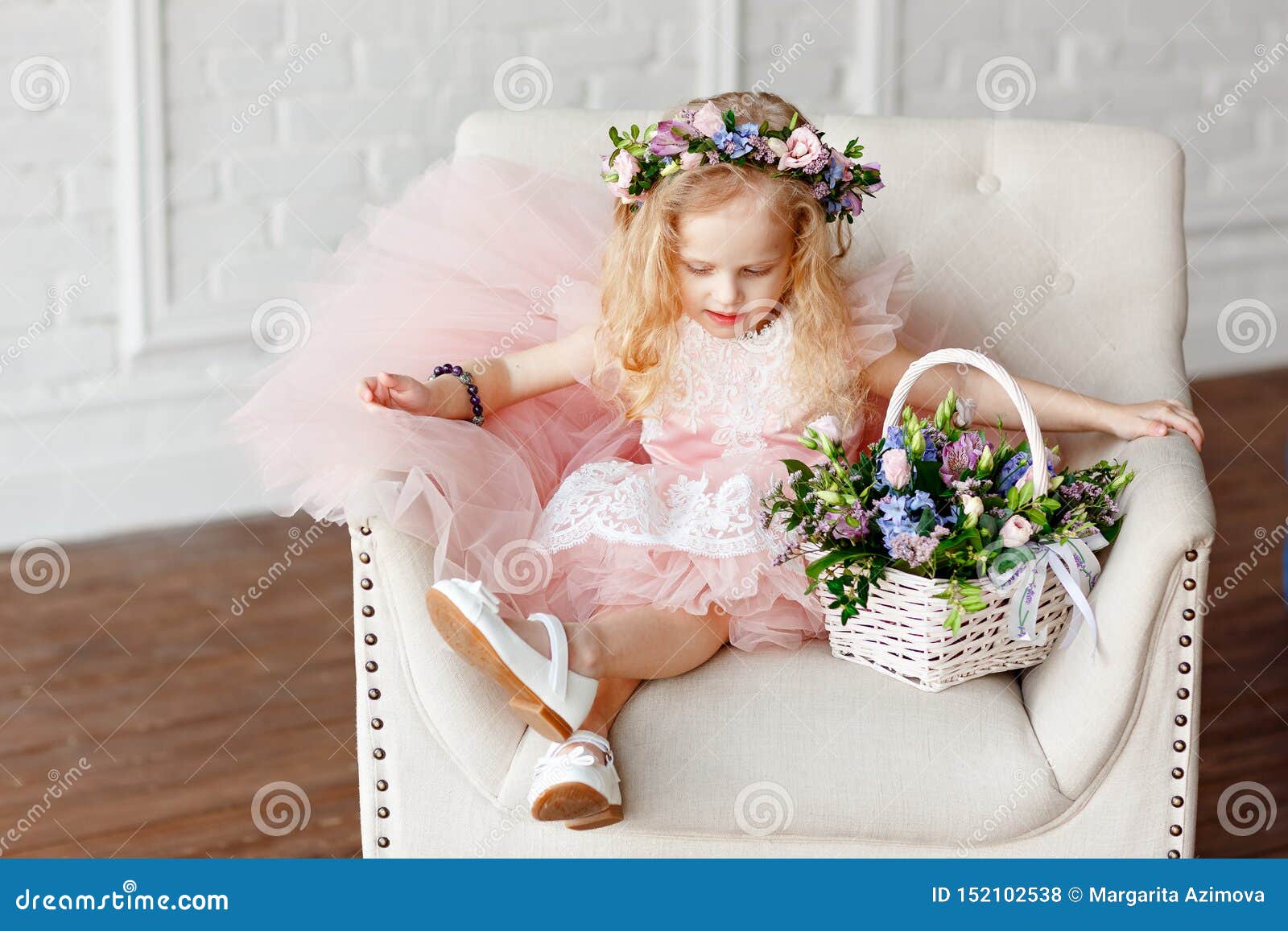 Un Enfant Mignon Fille Dans A Dans Une Couronne Rose De Robe Et De Fleur La Belle Petite Fille Dans Un Studio Lumineux S Assied Photo Stock Image Du Beau Coiffure