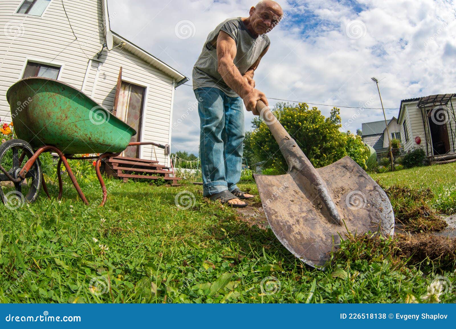 Un Fermier Avec Une Pelle Creuse Le Sol Dans Le Jardin Photo stock - Image  du expression, masculin: 226518138