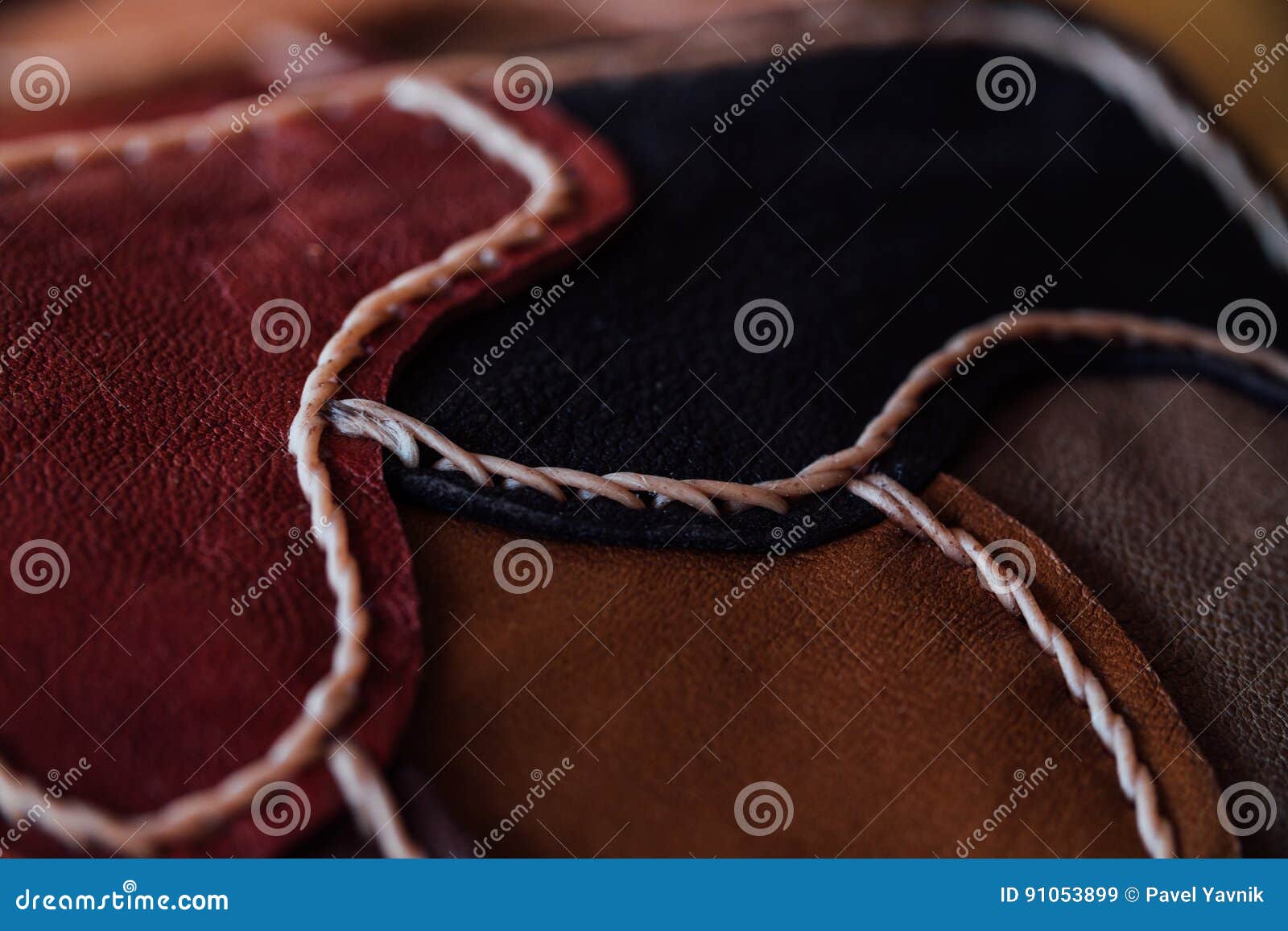 Un frammento di una borsa di cuoio e di una borsa fatte dei pezzi colorati multi Cucitura del cuoio bianco handmade Macro, primo piano