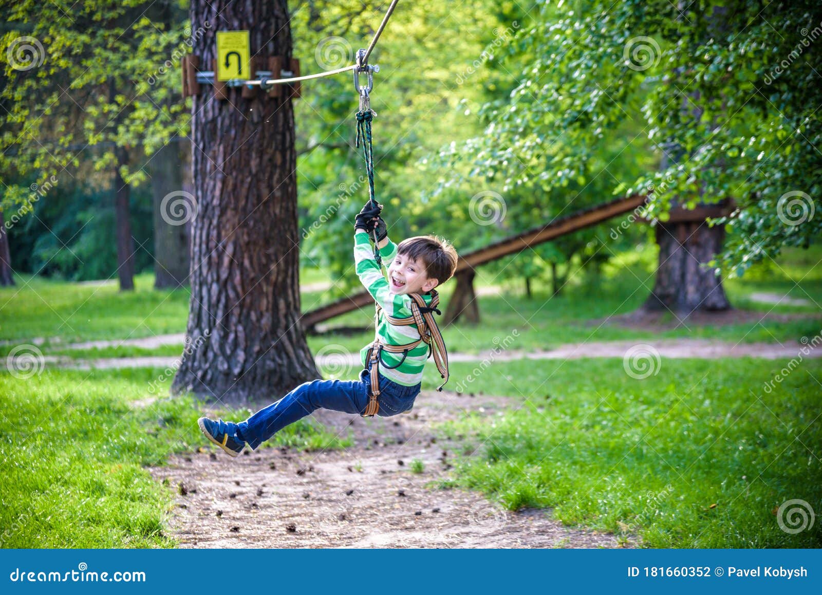 Garçon Souriant Chevauche Une Tyrolienne. Enfant Heureux Sur La