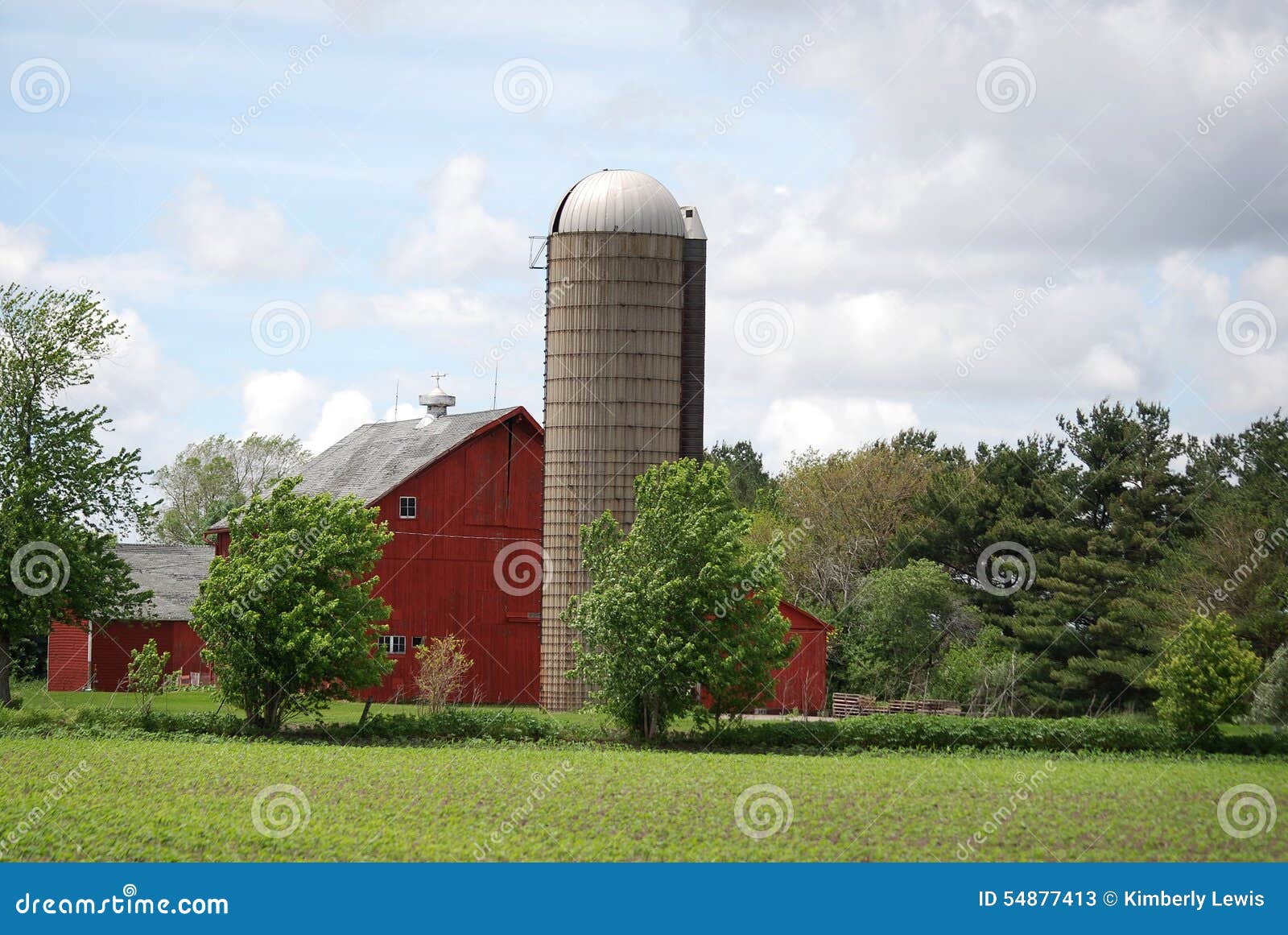 Un granero y un silo rojos brillantes en una granja en Illinois rural. Un granero rojo brillante con el silo en una granja en un día nublado en Illinois rural