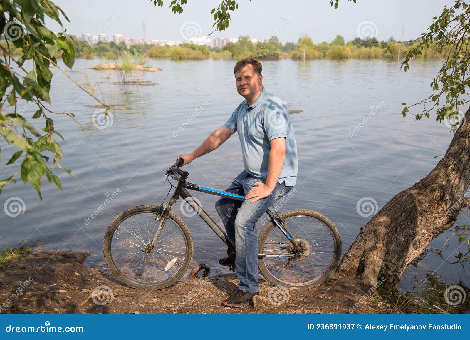 Un Hombre Adulto Alto Con Un Ribereño De Bicicleta Sobre Un Soleado Imagen  de archivo - Imagen de viejo, riverbank: 236891937