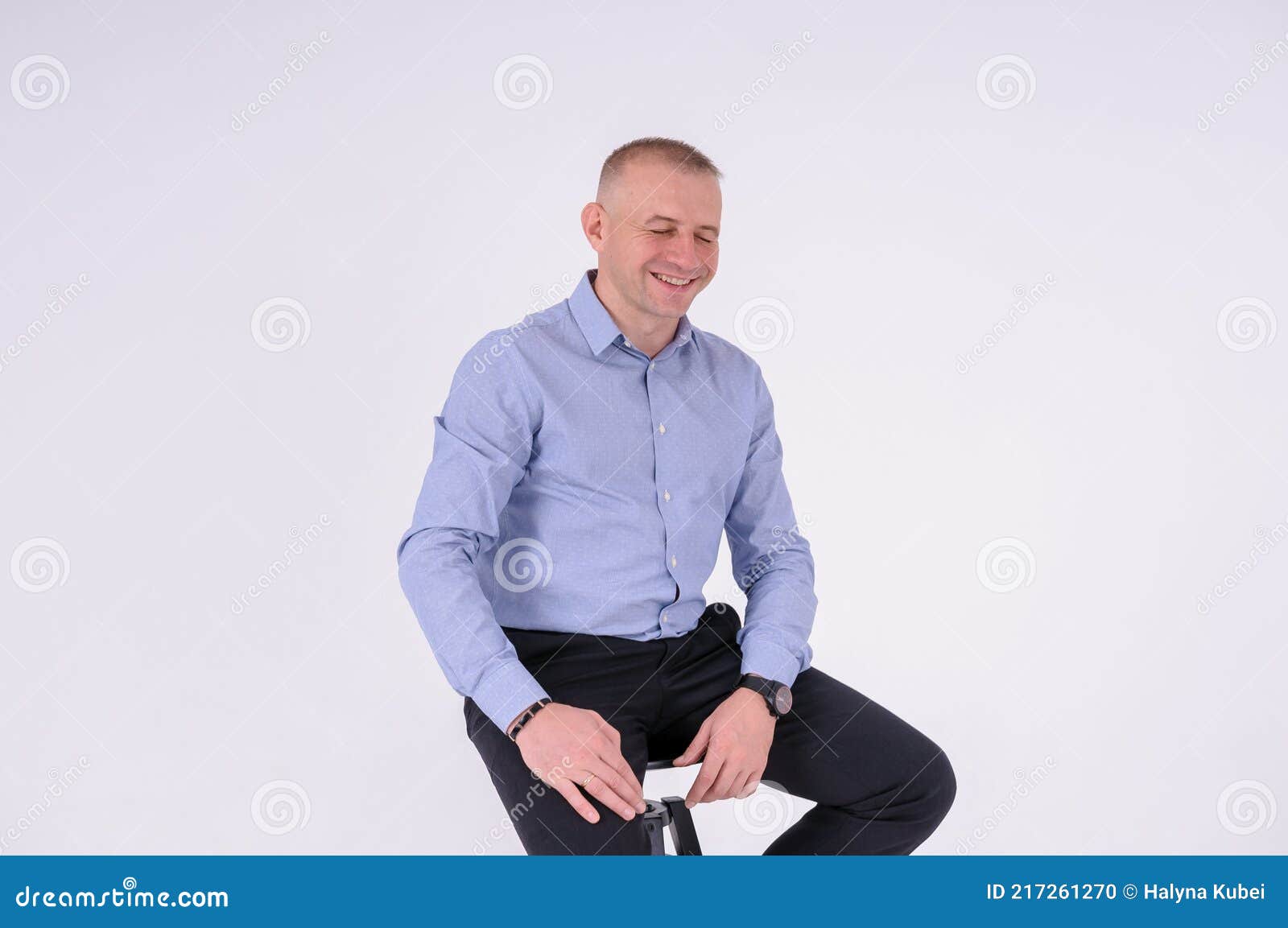 Un Hombre Con Camisa Azul Pantalón Negro Se Sienta En Taburete Sobre Fondo Foto de archivo - Imagen de silla, confidente: 217261270