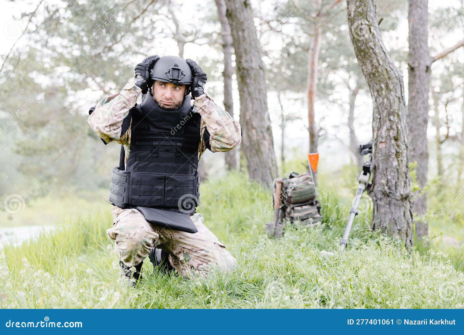 Un Hombre Con Uniforme Militar Y Un Chaleco Antibalas Trabaja En El Bosque  Para Desminar El Territorio. Un Hombre Se Pone Un Casco Imagen de archivo -  Imagen de battlefield, mirando: 277401061