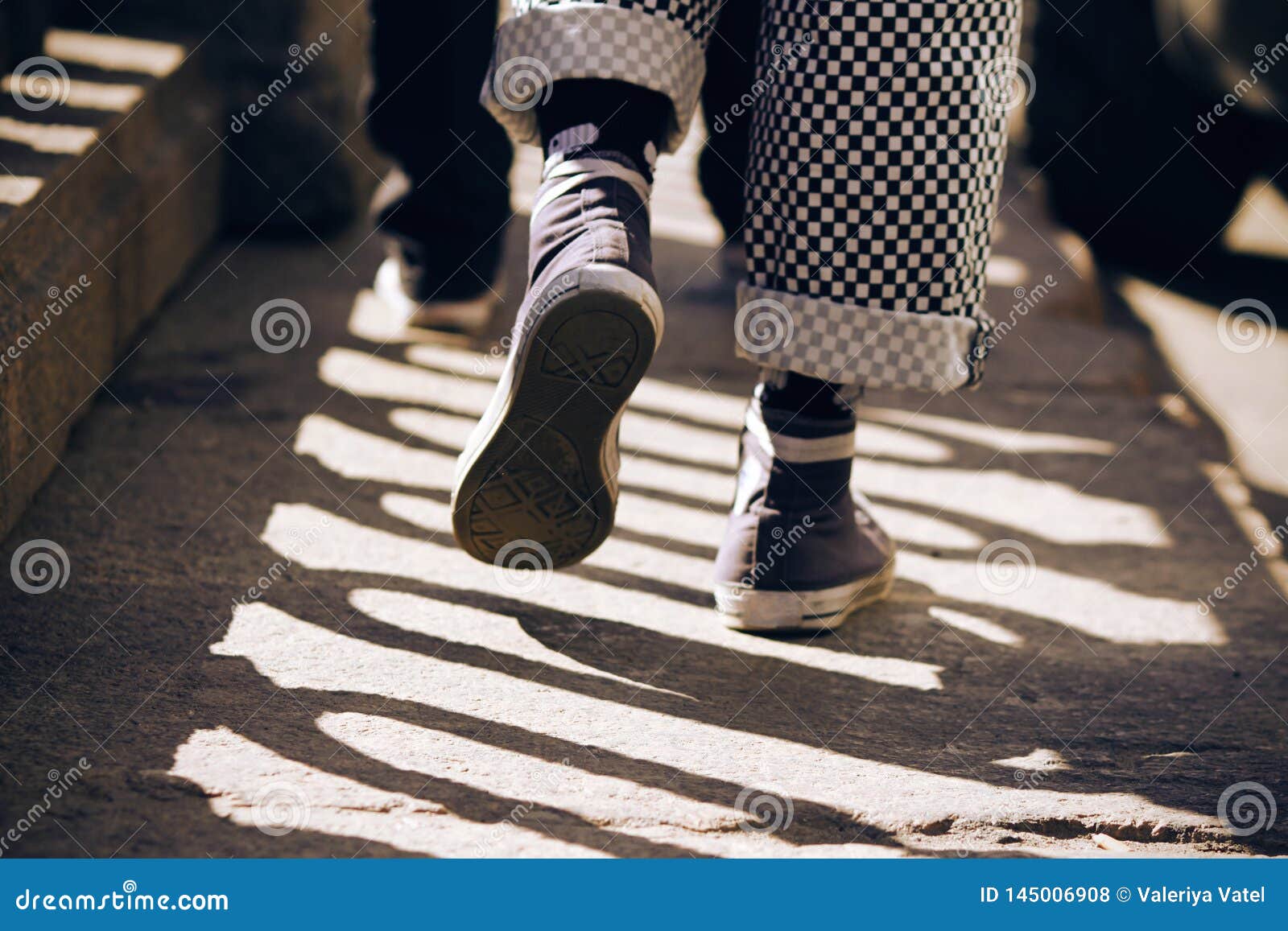 Un Hombre En Zapatillas De Deporte Y Pantalones De Tela Escocesa Que Camina En El Pavimento Foto De Archivo Imagen De Deporte Zapatillas 145006908