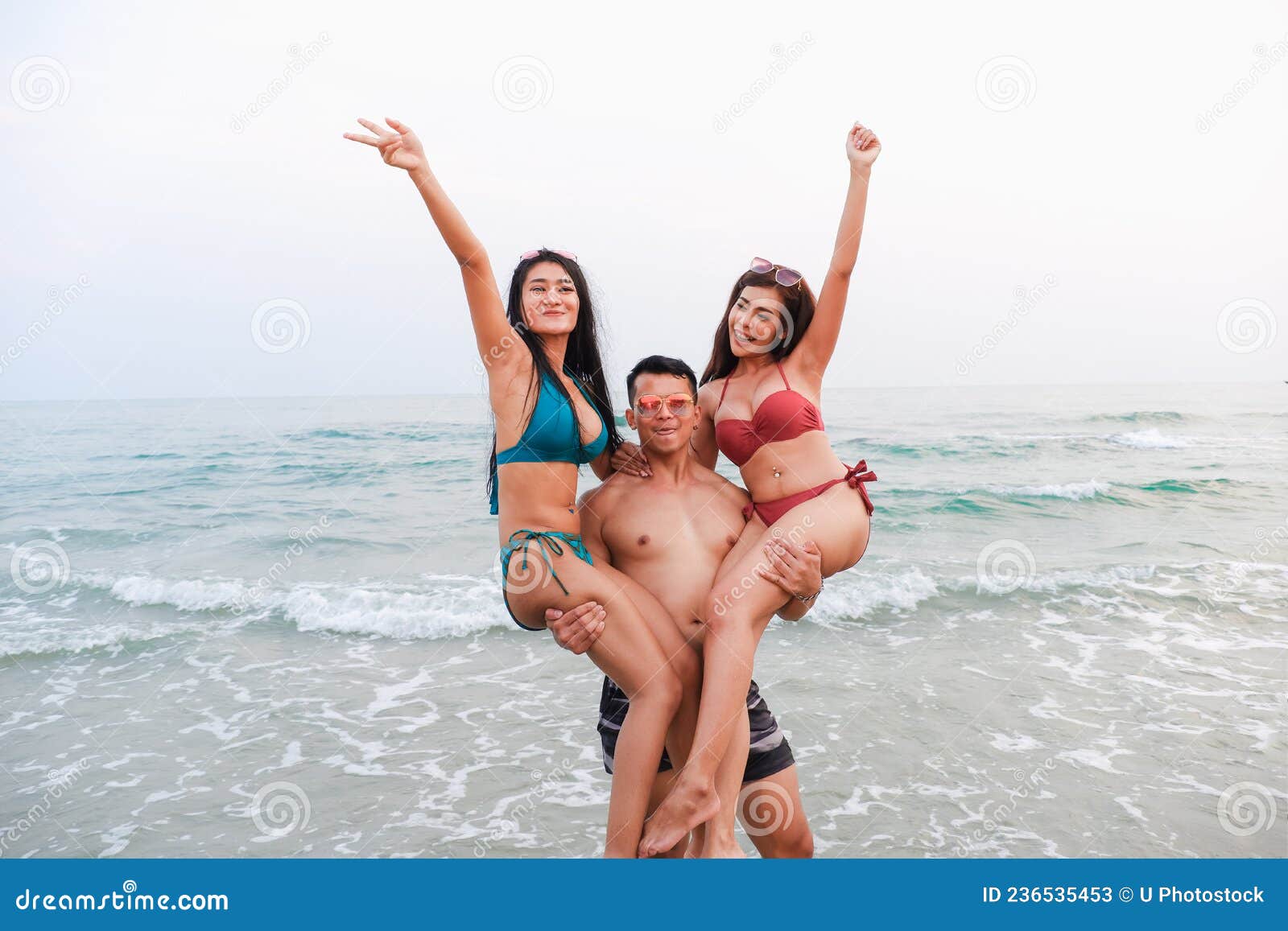 Anémona de mar Empleado pubertad Un Hombre Guapo Lleva a Mujeres Con Bikini En La Playa Imagen de archivo -  Imagen de atractivo, arena: 236535453