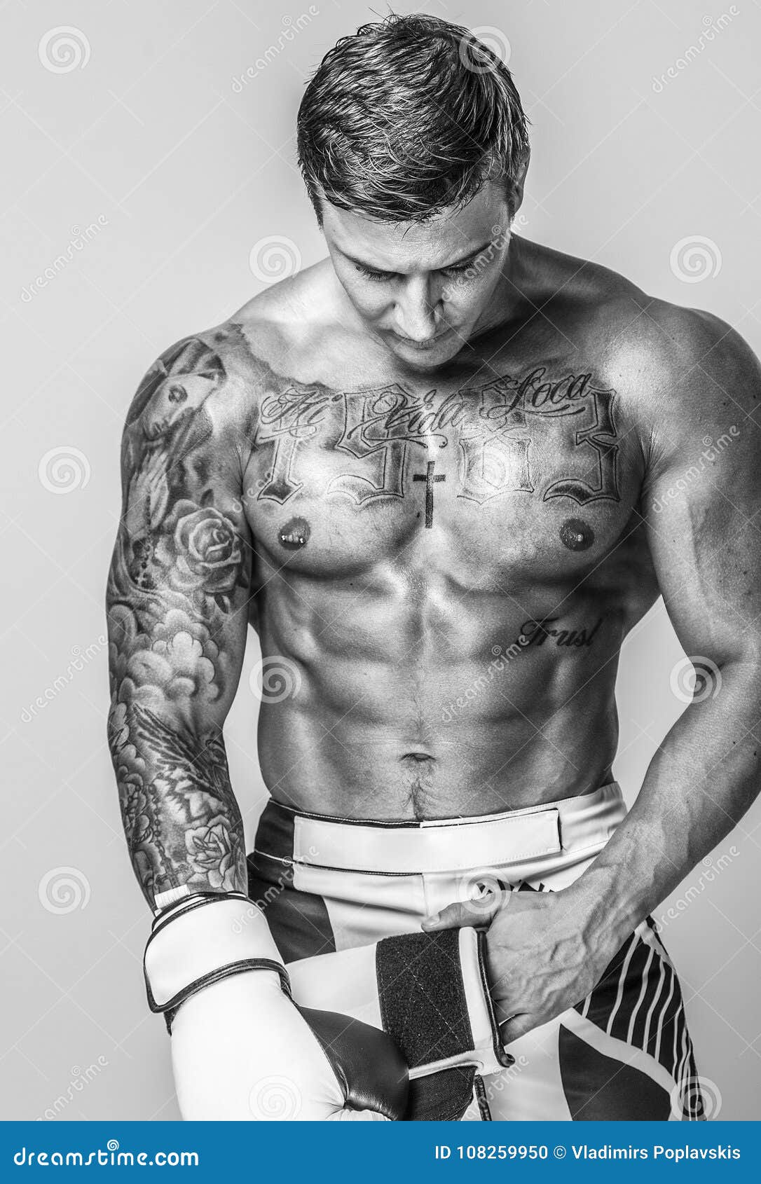 Hombre musculoso posando en el gimnasio con un cinturón atlético