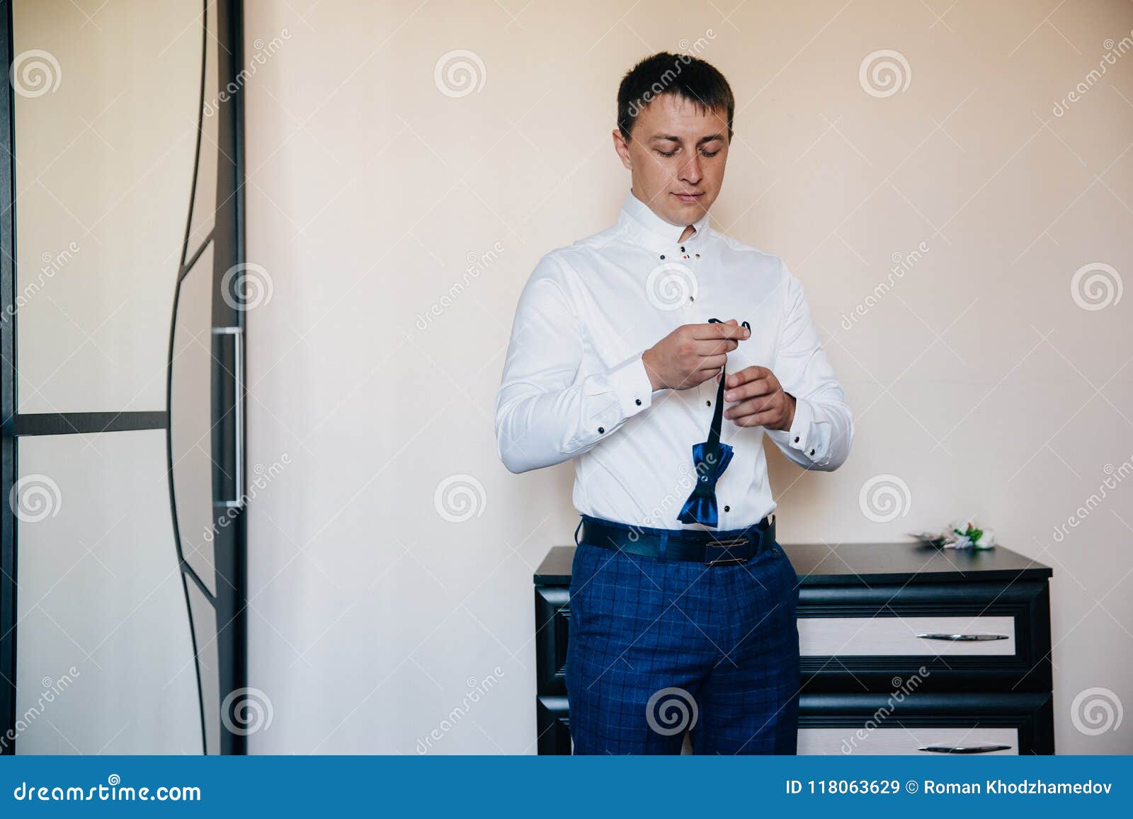 Un Hombre Pone Una Corbata De Lazo Y Va a Su Boda Un Individuo En Pantalones En Una Jaula Y Una Camisa Blanca Está Consiguiendo L Imagen de archivo - Imagen de Un Hombre Pone Una Corbata De Lazo Y Va a Su Boda Un Individuo En Pantalones En Una Jaula Y Una Camisa Blanca Está Consiguiendo L Imagen de archivo - Imagen de