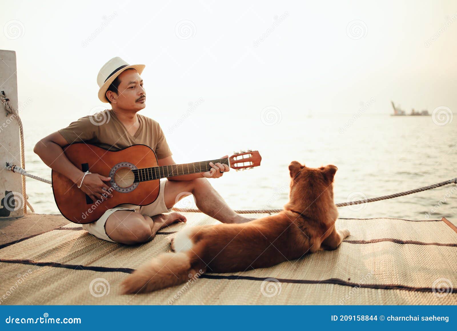 Prefijo Destino Preferencia Un Hombre Usa Sombrero De Paja Y Toca Música De Guitarra Cerca De La Puesta  De Sol Del Mar Con Una Mascota De Perro Foto de archivo - Imagen de  concepto, vacaciones: 209158844
