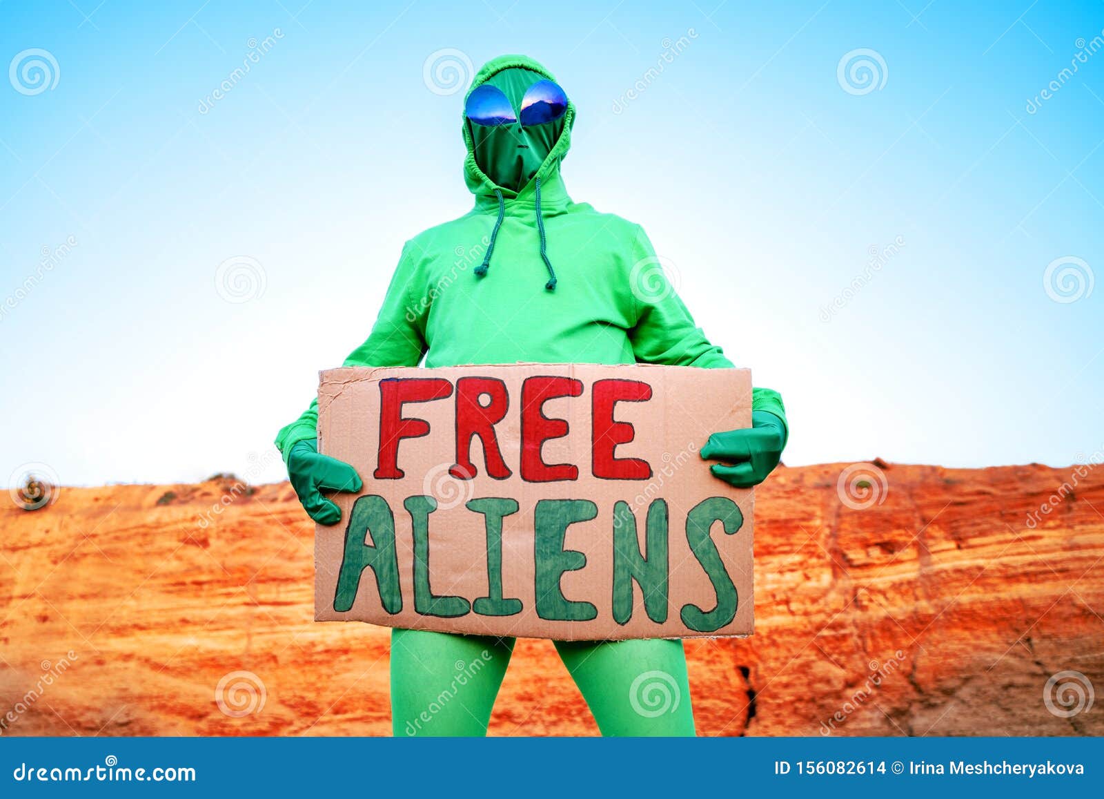 Un Hombre Vestido Con Traje De Carnaval Extraterrestre Verde En Una Sola  ManifestaciÃ³n Con Un Cartel 