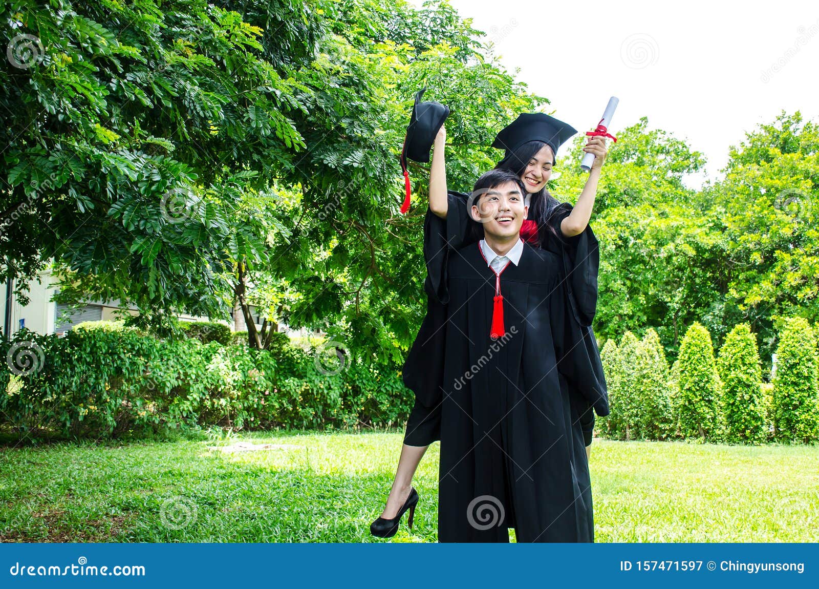 Un Hombre Y Una Pareja Vestidos Con Traje Negro De GraduaciÃ³n O Graduados  Con Felicitaciones Con Sombreros De GraduaciÃ³n EstÃ¡n Imagen de archivo -  Imagen de alegre, activo: 157471597