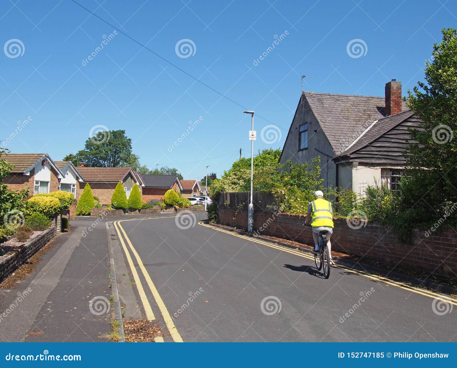 Un Homme Ã VÃ©lo Portant Un Gilet RÃ©flÃ©chissant Dans Une Rue De Bungalows  Typiques De Banlieue En Angleterre, Dans L'ancien Qua Image éditorial -  Image du route, jardins: 152747185