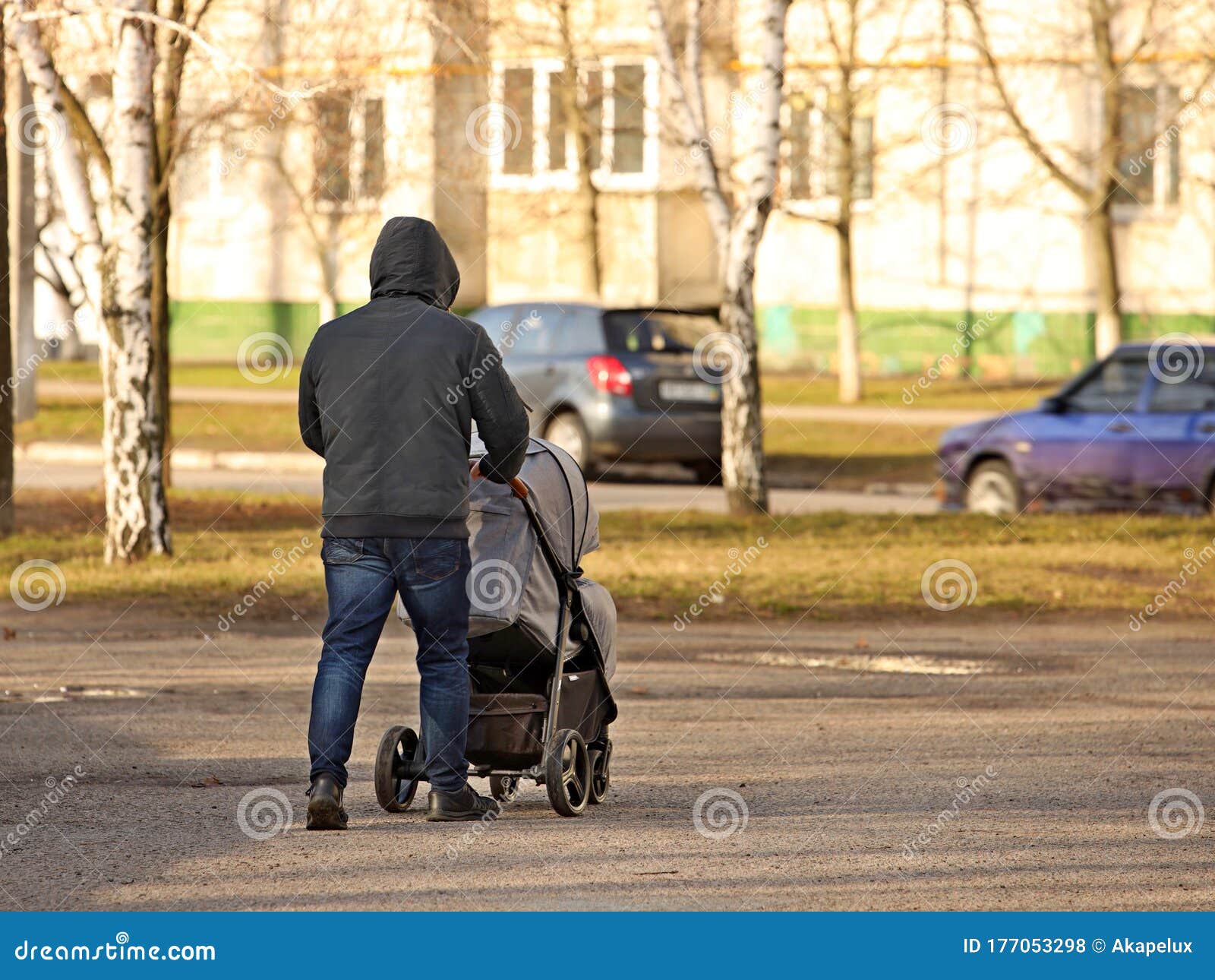 Un Homme Pousse Une Voiture D'enfant Devant Lui. Père Avec Un Enfant En  Promenade Autour Du Quartier. Pour S'occuper De L'éducatio Photo stock -  Image du adulte, chariot: 177053298