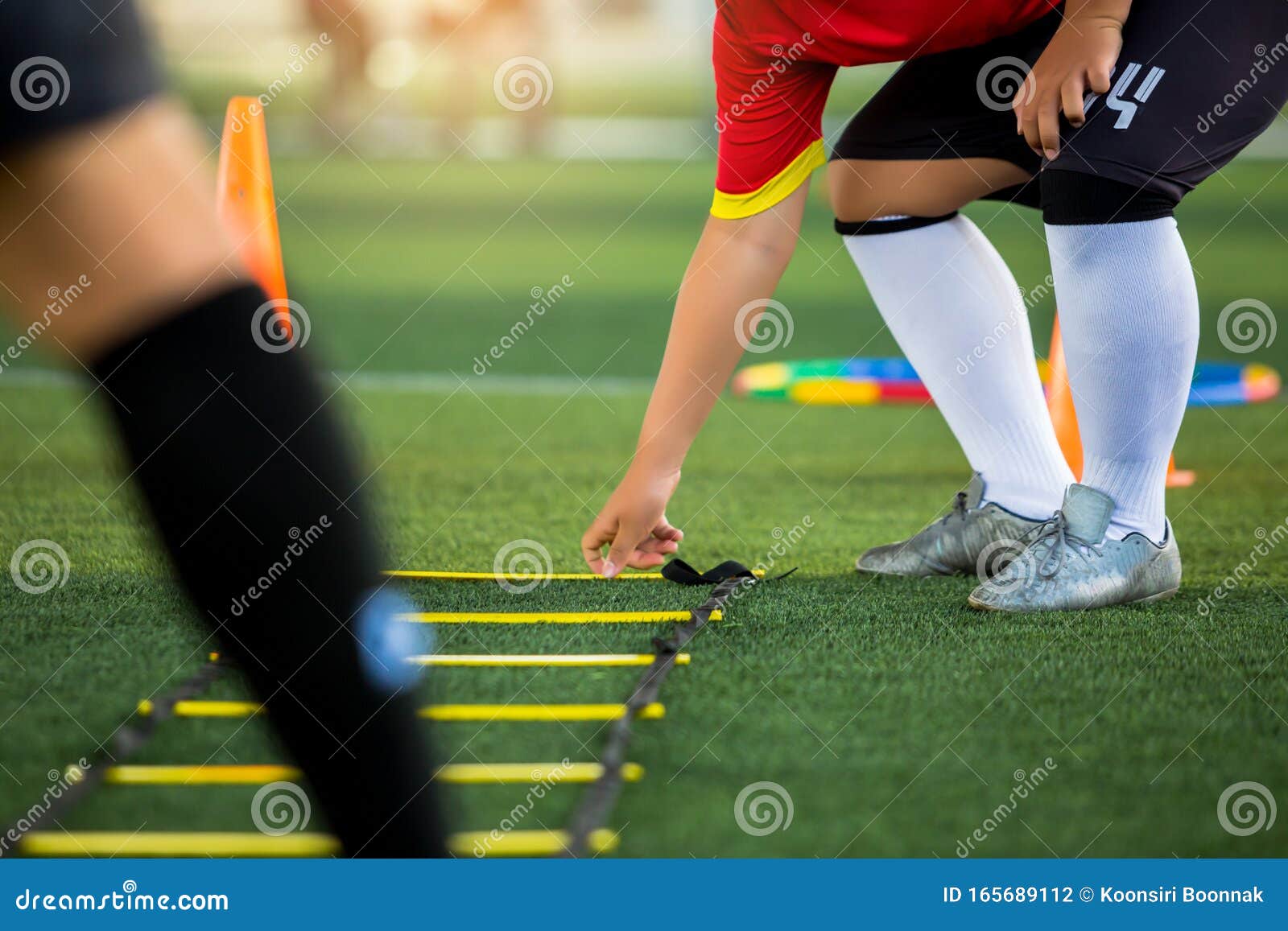 Un Jeune Footballeur Pose Les Exercices D'échelle Pour L