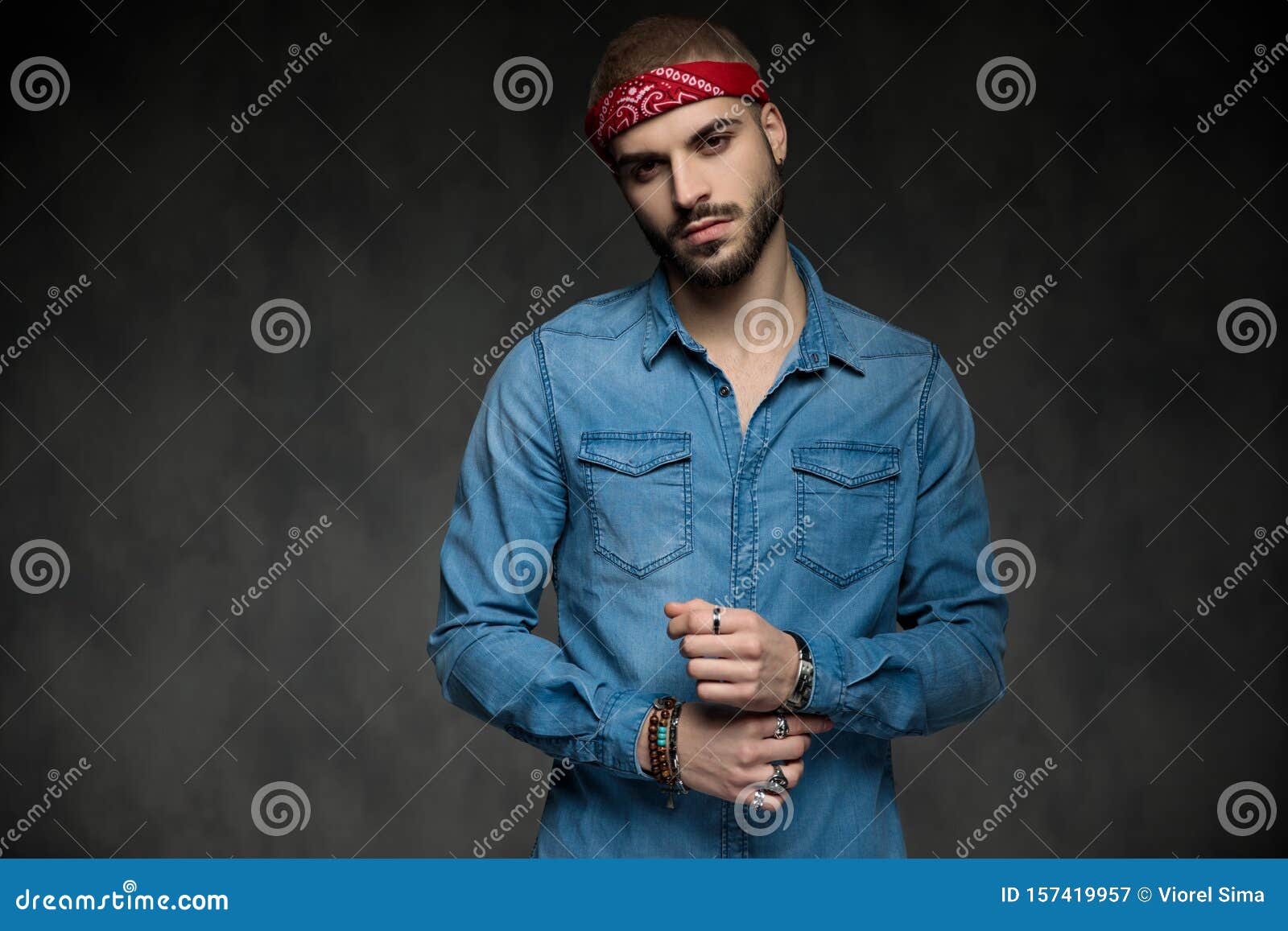 Un Jeune Homme Cool Portant Du Bandana Fixe Sa Manche Image stock