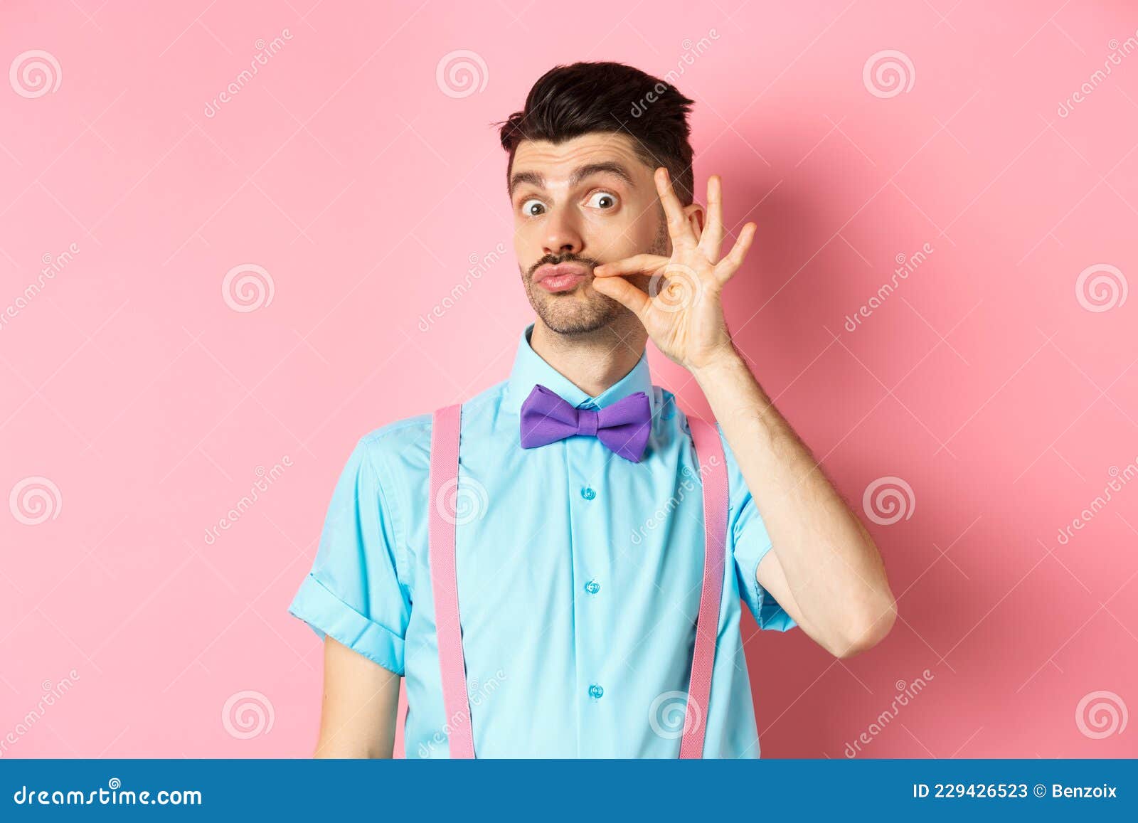 Un Jeune Homme Drôle Touchant Sa Moustache Française Et Les Lèvres De  Pucker Regardant Ridicule La Caméra Debout Dans Le Cul Et Image stock -  Image du homme, type: 229426523