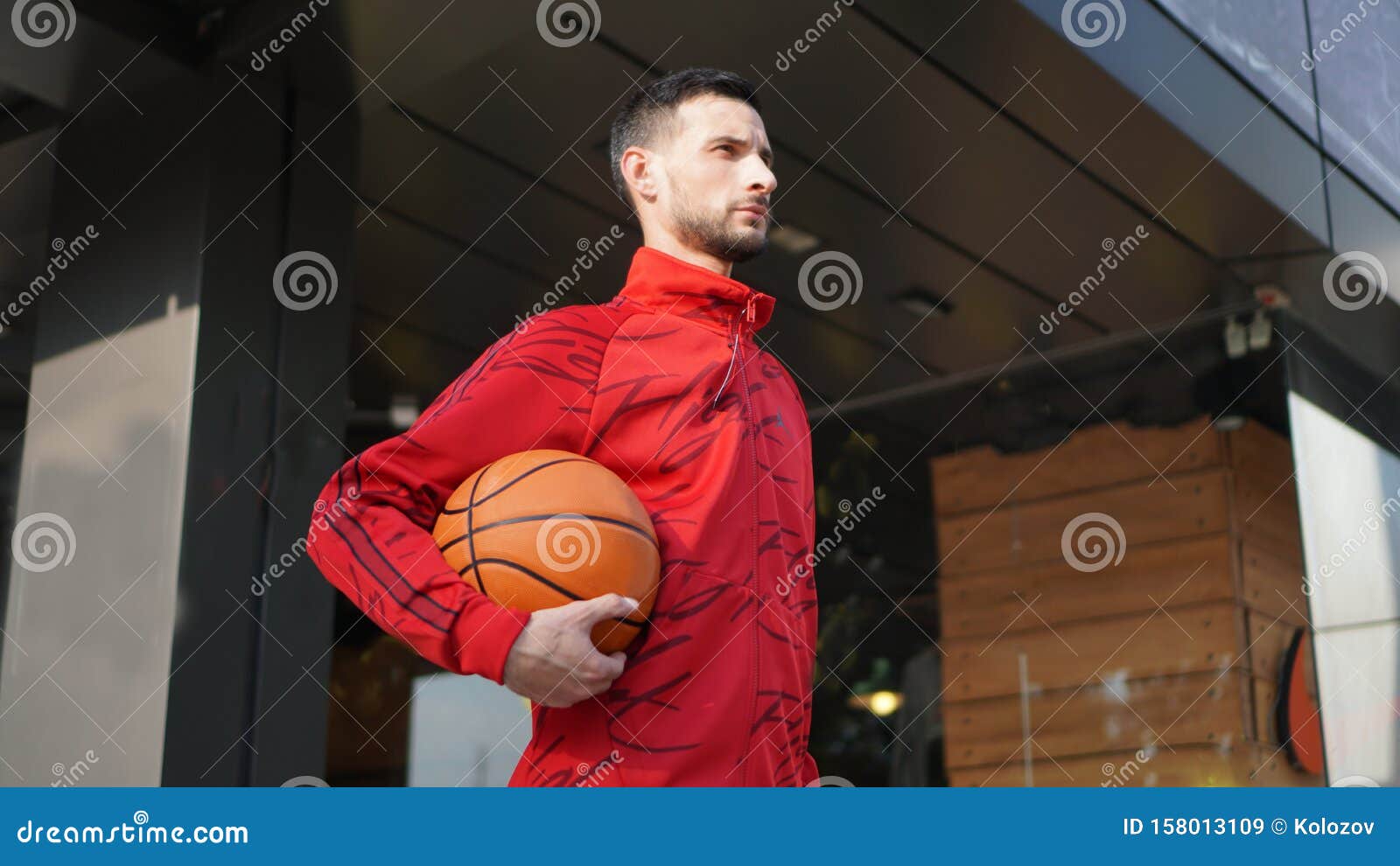 Un Jeune Homme En Costume D'entraînement Pose Avec Le Basket-ball Devant Le  Magasin Image stock - Image du persistance, bille: 158013109