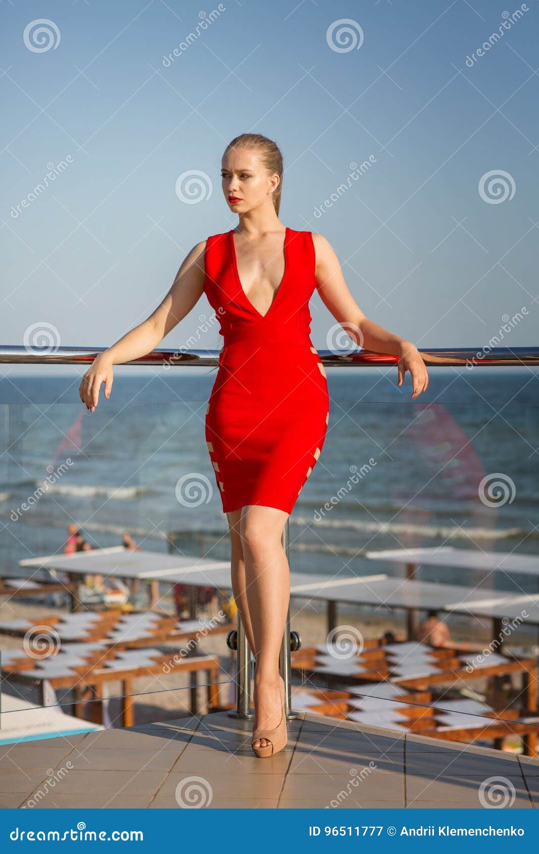 Un Modelo Joven Atractivo En Vestido Rojo Brillante Está Presentando En Un Fondo Azul Del Mar Encantadora Con El Cuerpo Imagen de archivo - de palma, lifestyle: 96511777