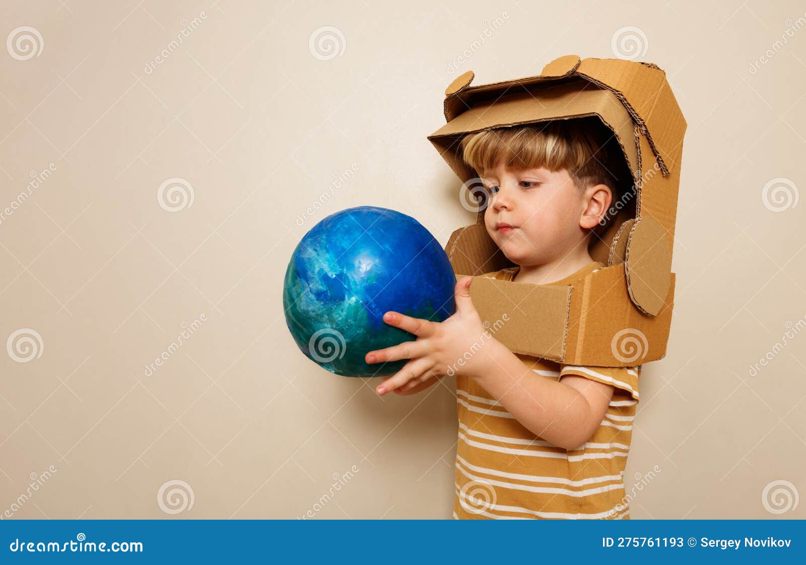 Un Niño Con Casco Astronauta De Cartón Sostiene El Planeta Tierra Imagen de  archivo - Imagen de mano, cohete: 275761193