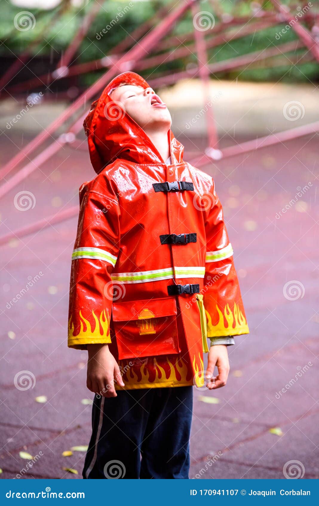 omitir sobrino Oficiales Un Niño Gracioso Vestido Con Un Bombero De Impermeable Rojo Juega En Un  Parque En Un Día Lluvioso Imagen de archivo - Imagen de sucio, exterior:  170941107