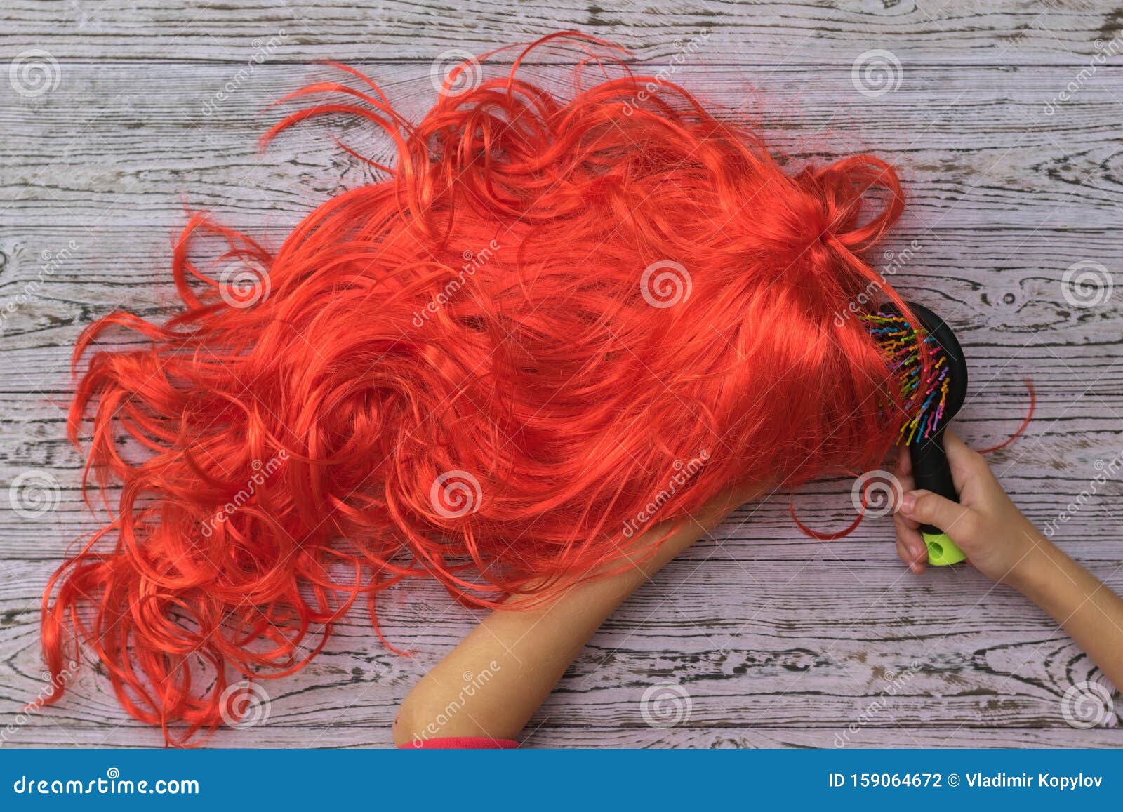 Un NiÃo Peina Una Peluca Con Un Peine De Masaje Sobre Un Fondo De Madera  Foto de archivo  Imagen de hairdryer cuidado 159064672