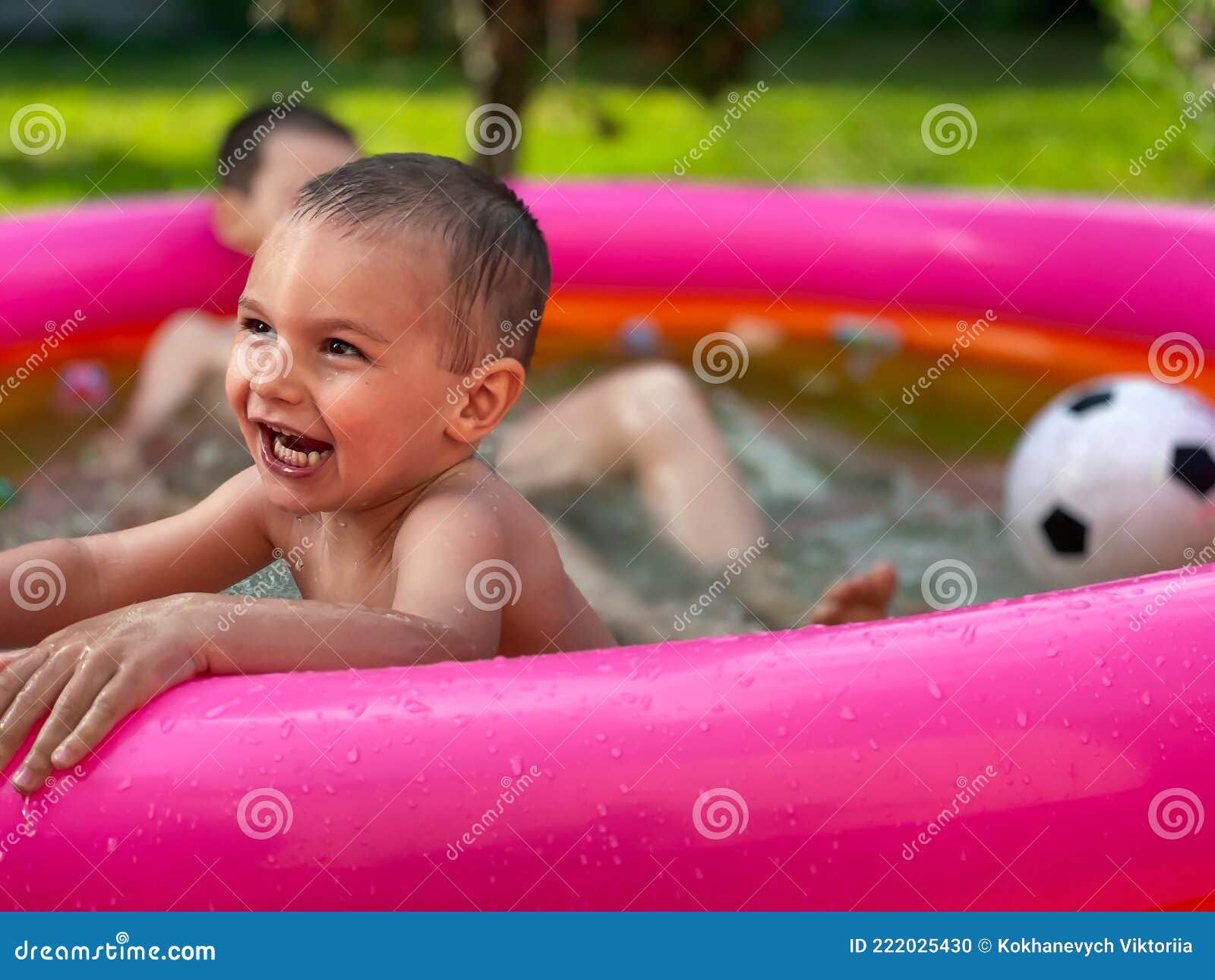 Un Petit Enfant Dans Un Bassin Gonflable Pour Enfants En été Photo