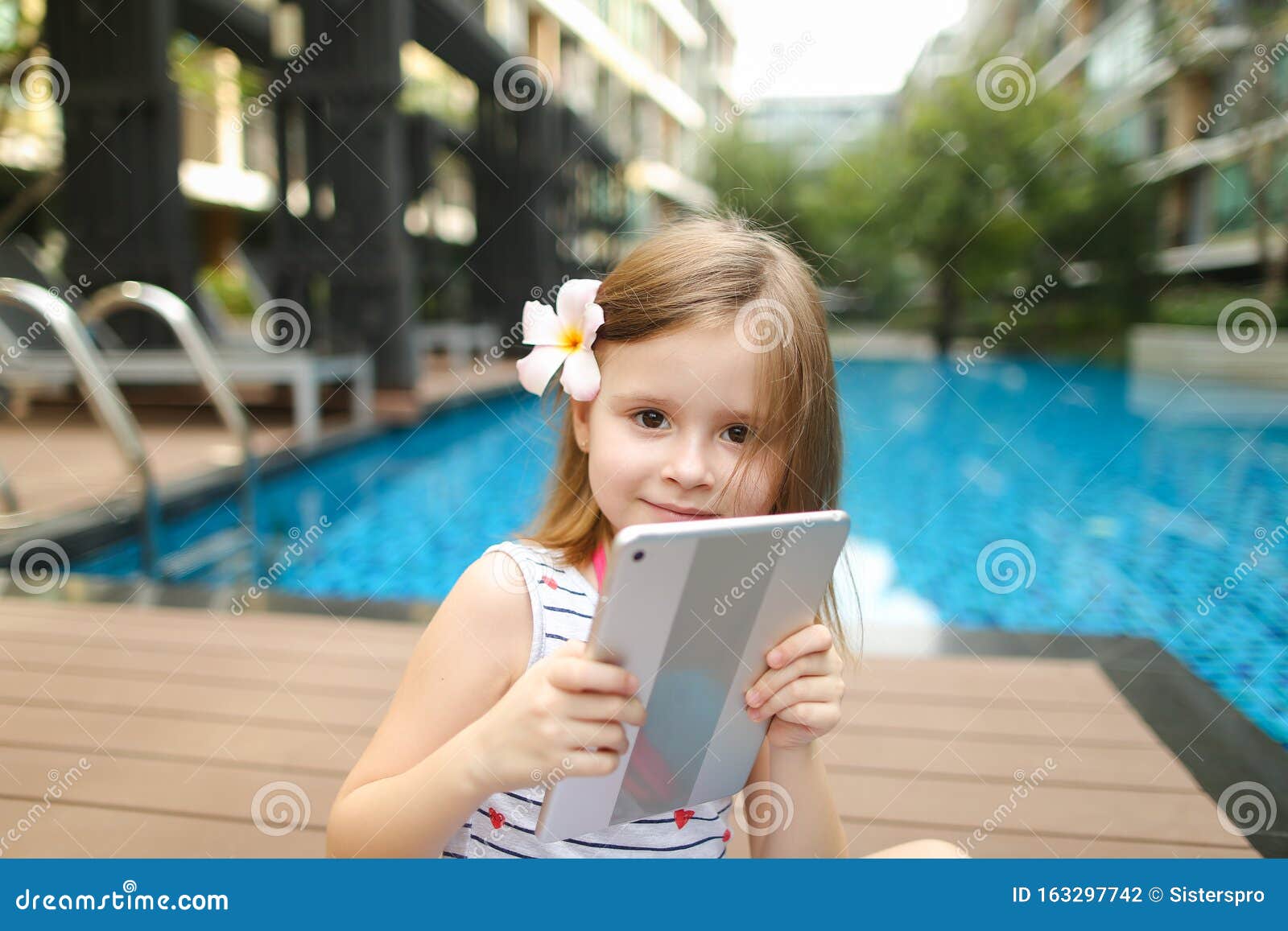 Un Petit Enfant En Selfie Sur Sa Tablette Près De La Piscine Photo stock -  Image du heureux, loisirs: 163297742