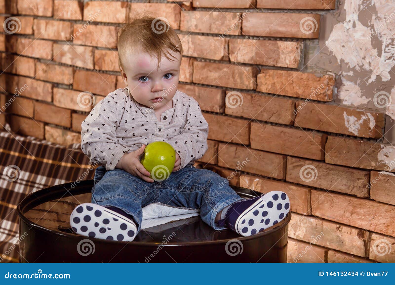 Un Petit Enfant S Assied Sur Un Baril De Fer Et Tient Une Pomme Dans Des Ses Mains Bebe Garcon Avec Le Fruit Sur Le Fond Du Mur D Photo Stock Image Un Petit Enfant S Assied Sur Un Baril De Fer Et Tient Une Pomme Dans Des Ses Mains Bebe Garcon Avec Le Fruit Sur Le Fond Du Mur D Photo Stock Image