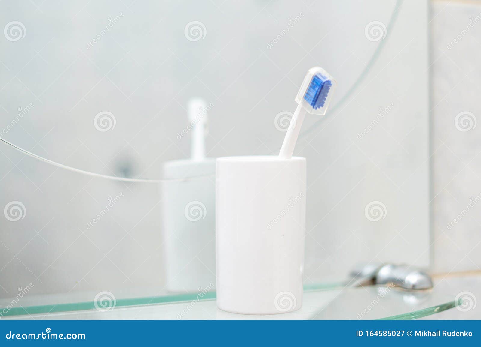 Un Simple Cepillo De Dientes En Un Vaso De Baño Imagen de archivo - Imagen  de higiene, toothpaste: 164585027