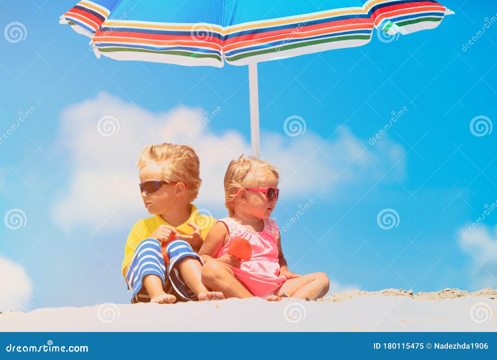 Un Para Niños Y Niñas Bajo Sombrillas En La Playa De Verano Imagen de archivo - Imagen de familia, sombrilla: 180115475