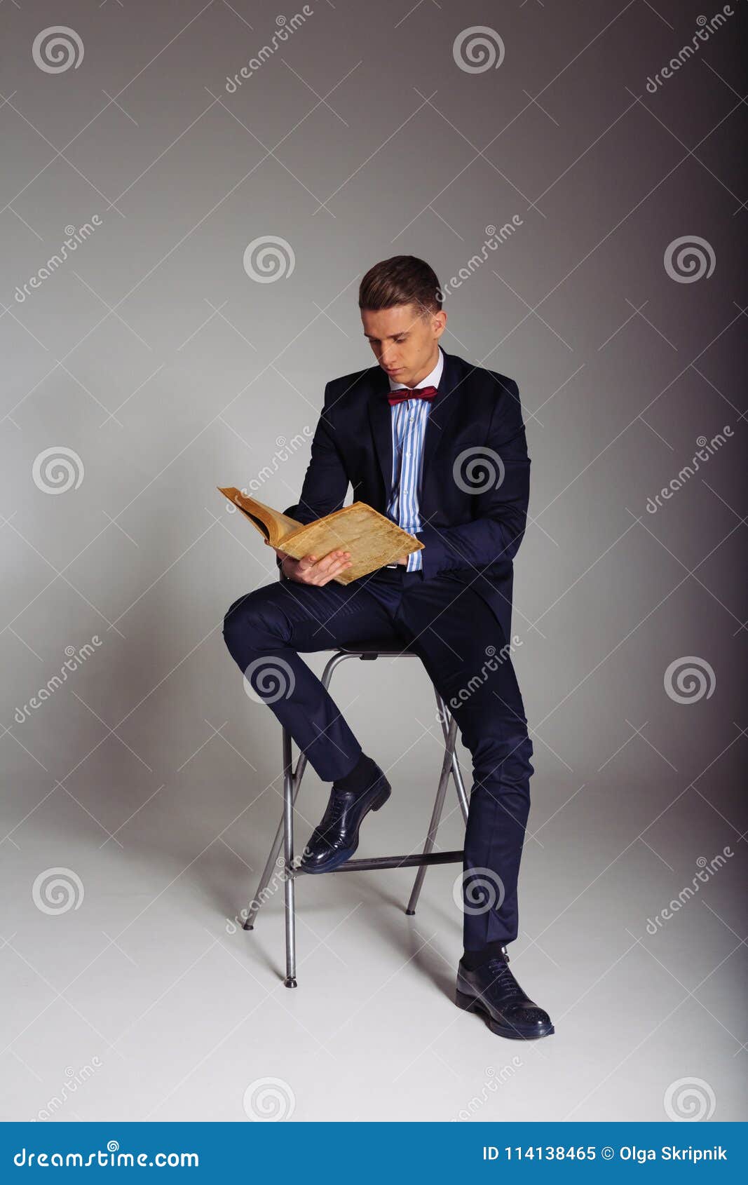 Un Uomo, Un Tipo in Un Vestito Blu, Si Siede Su Una Sedia E Legge Un  Vecchio Libro, Il Concetto Di Conoscenza, Lo Studio, La Scie Immagine Stock  - Immagine di rosso