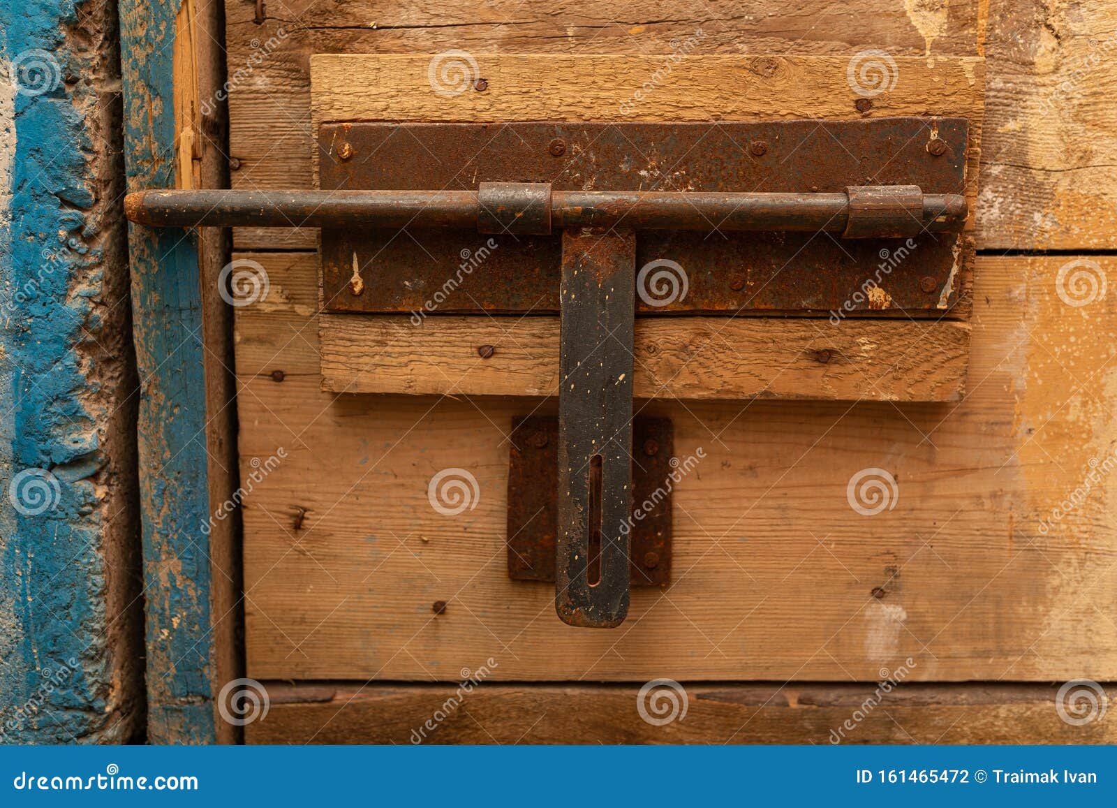 Un vieux loquet rouillé d'une porte en bois brut. Un vieux loquet corrodé d'une porte en bois dentelée