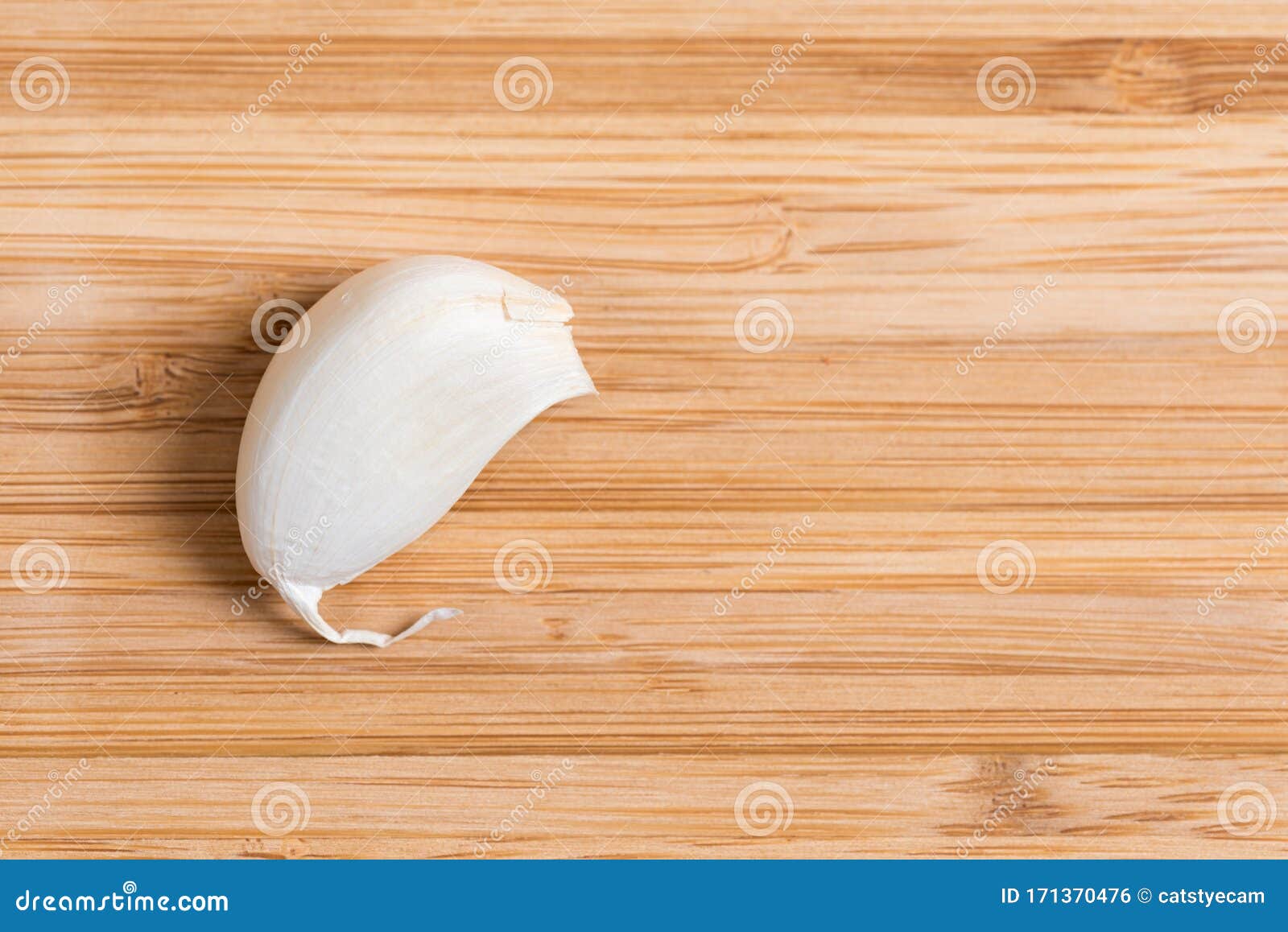 Vista superior de un único clavo de ajo sobre una mesa de cocina de madera