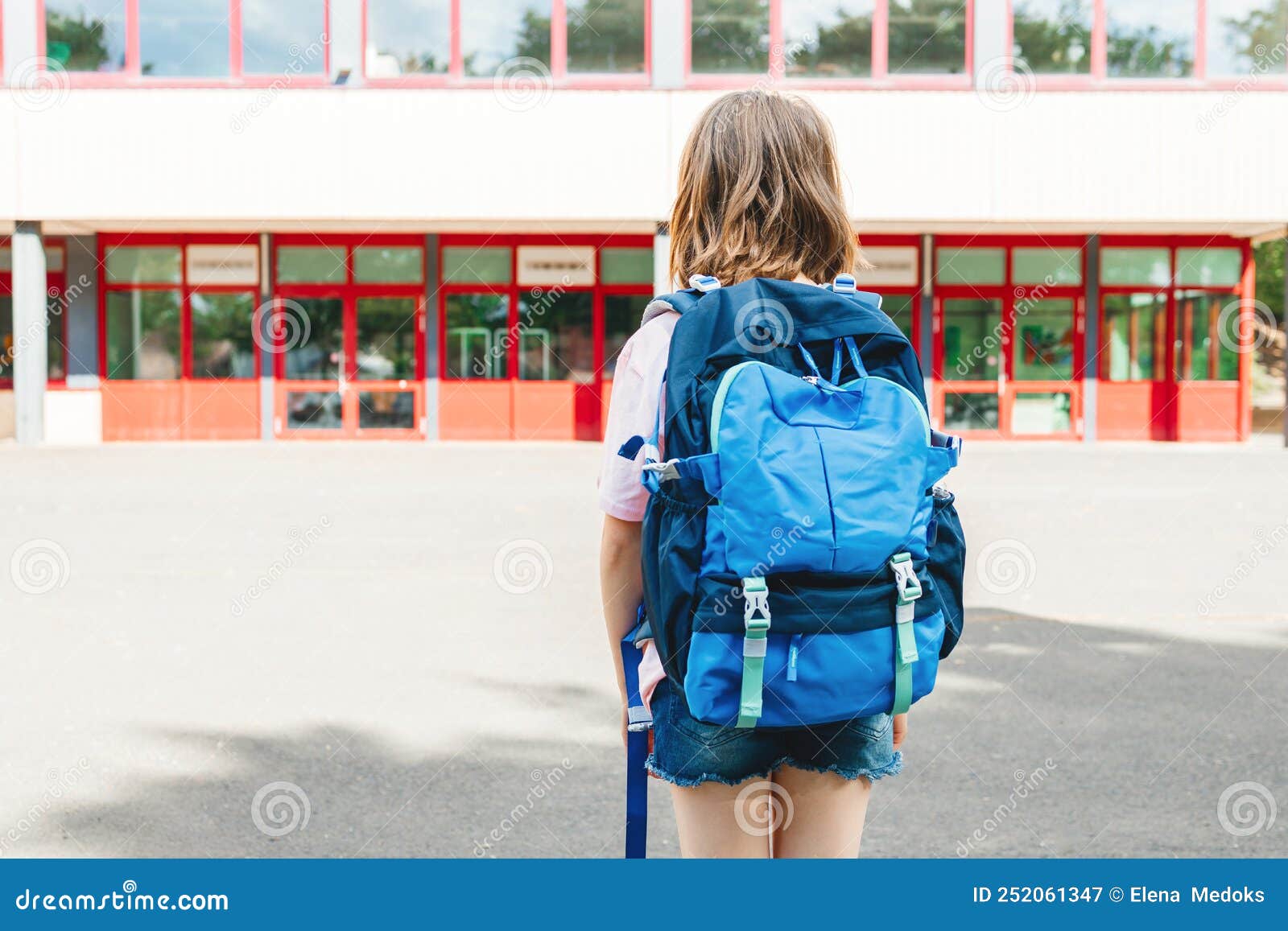 Una Adolescente Con Una Mochila Escolar En La Espalda Se Para Frente a La  Escuela Y La Mira. Inicio Del Imagen de archivo - Imagen de vacaciones,  eduque: 252061347