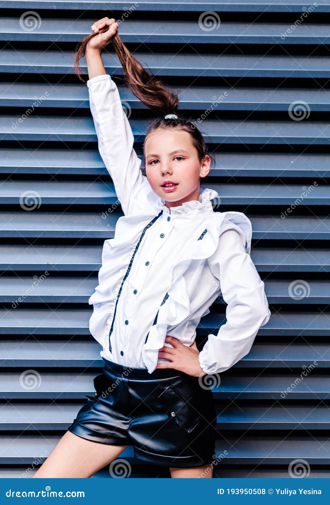 Una Bella Y De Moda Colegiala Con Una Blanca Y Pantalones Cortos Negros Con Una Cola En La Cabeza La Cola Con La Foto de archivo - Imagen de