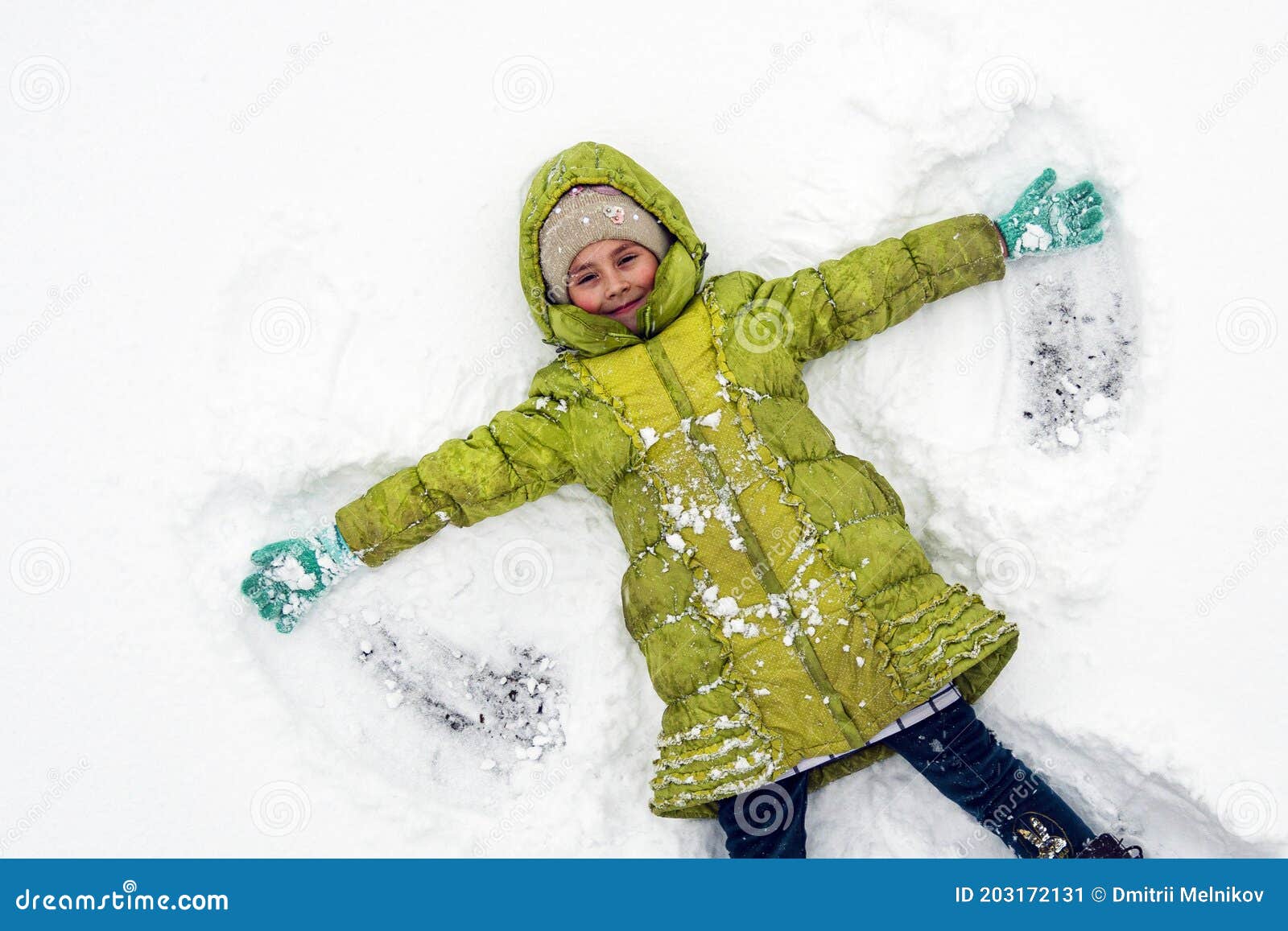 Una Chica Una Chaqueta Verde Juega En La Nieve Cuando Hace Frío. Vista Superior De Niña Adorable Disfrutando Lo Hermoso Imagen de archivo - Imagen de disfrute, retrato: