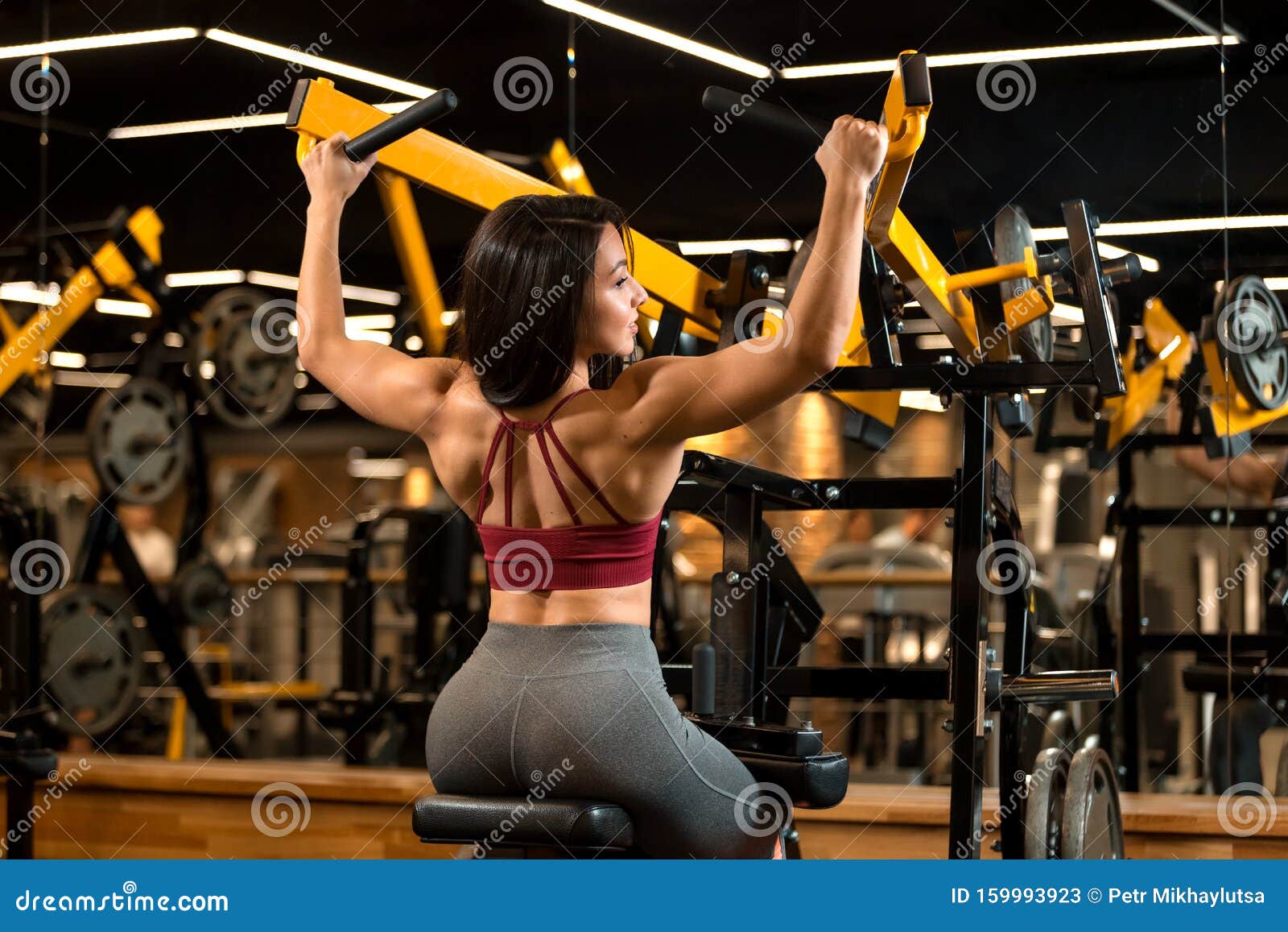 Una Chica Sexy Del Gimnasio EstÃ¡ Sentada Haciendo Ejercicios De Hombro En  El Entrenador Imagen de archivo - Imagen de deporte, hermoso: 159993995