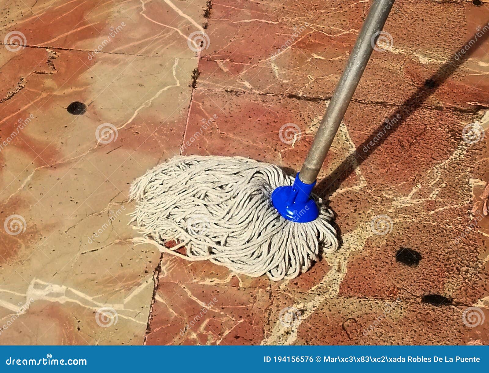 una fregona limpiando un suelo de baldosas