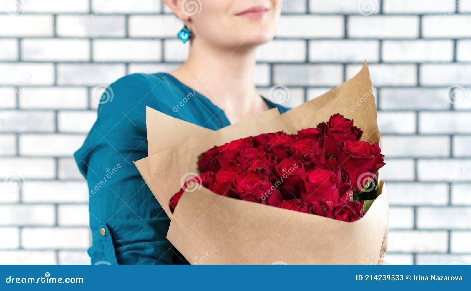 Una Guapa Chica Con Camisa Azul Sostiene Lujoso Ramo De Rosas Rojas Envuelto En Papel Artesanal Y Sonríe. Combinación De Rojo Y Imagen de archivo - Imagen de primer, hermoso: 214239533