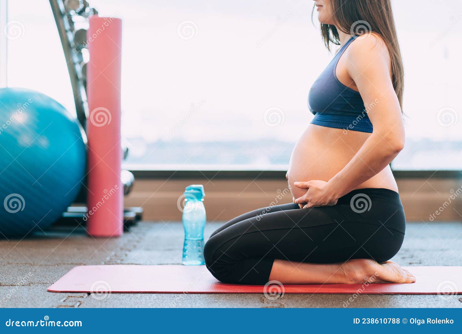 Una Joven Embarazada En Ropa Deportiva Medita Sentada Con El Vientre Sobre  Un Tapete Rosado Después De Practicar Yoga Cerca De Una Foto de archivo -  Imagen de bebé, gimnasio: 238610788
