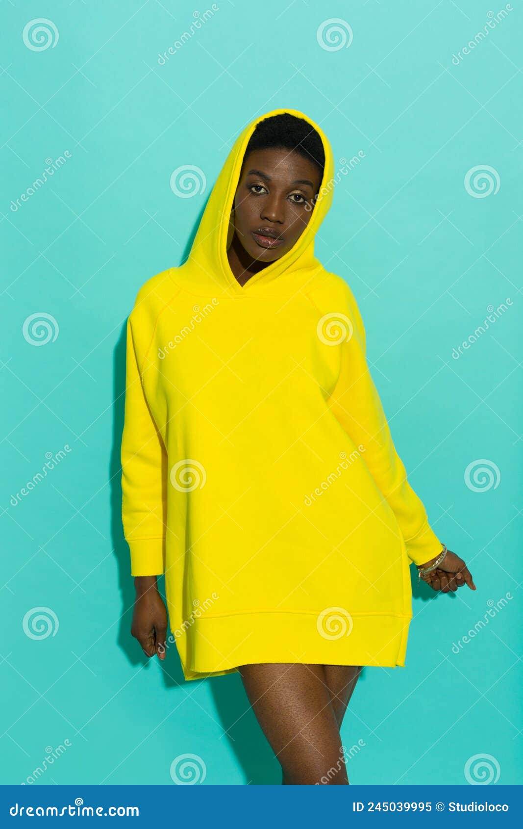 Una Joven Mujer Negra Posa En Una Sudadera Gorda Amarilla Y  Sobredimensionada Imagen de archivo - Imagen de capucha, negro: 245039995