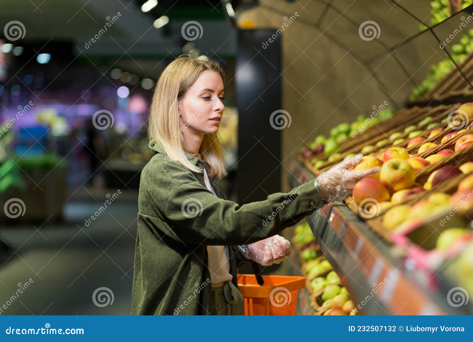 Una Joven Rubia Elige Frutas Verduras En El Mostrador Del Supermercado imagen