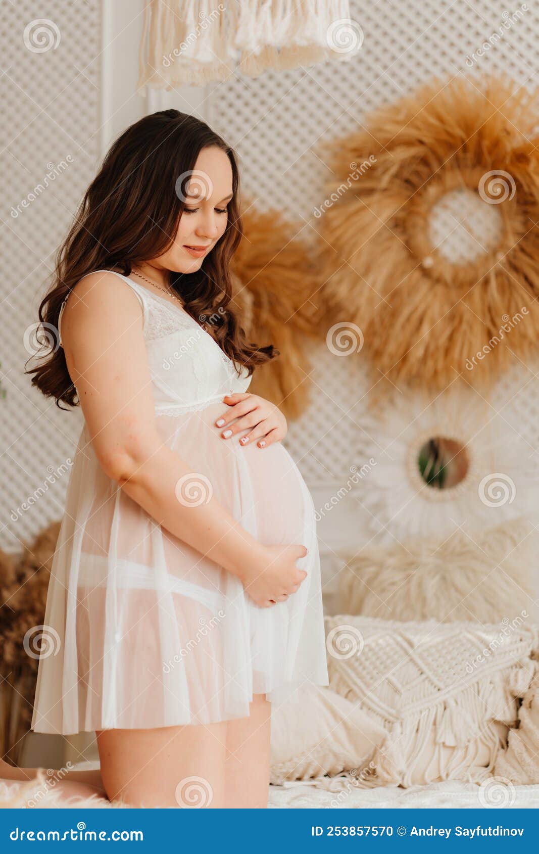 Una Mujer Embarazada Con Un Peignoir Blanco En La Cama. Ropa Sexy